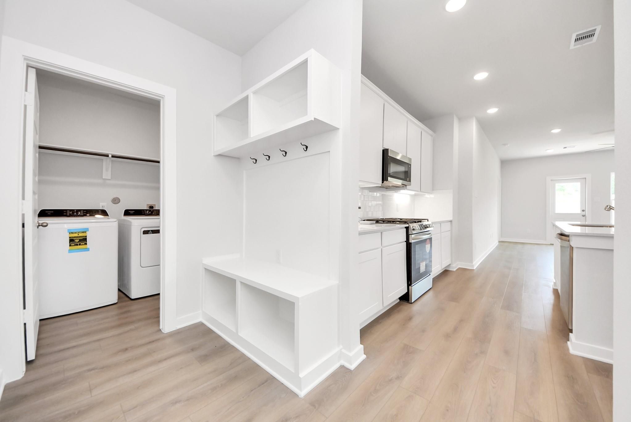 Mudroom drop zone with built-in storage bench next to laundry room in The Blanco E floor plan at The Villages at WestPointe.