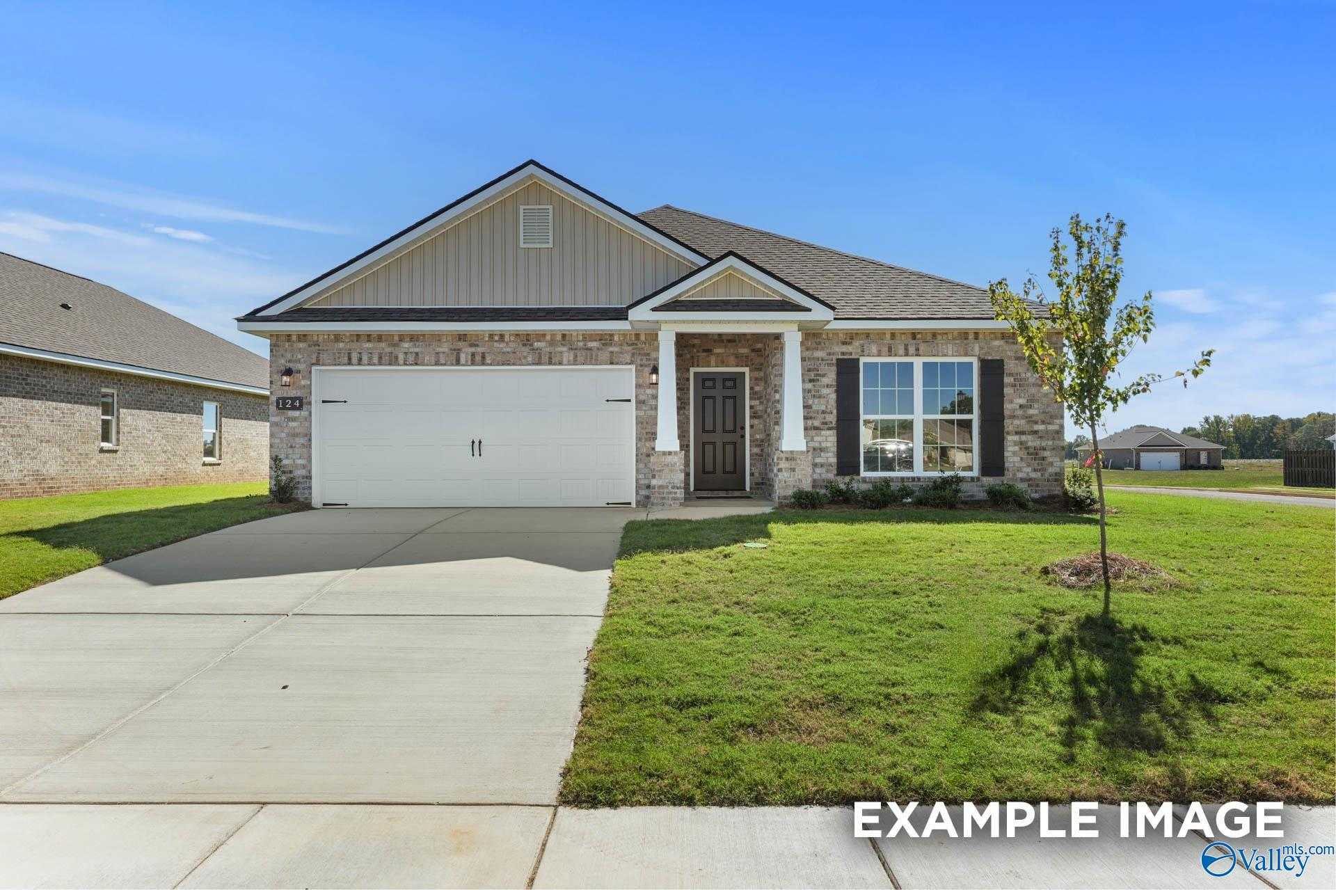 Modern 1-story brick home with 2-car garage, front porch, and lush lawn in Ramsay Cove, Owens Cross Roads, Alabama