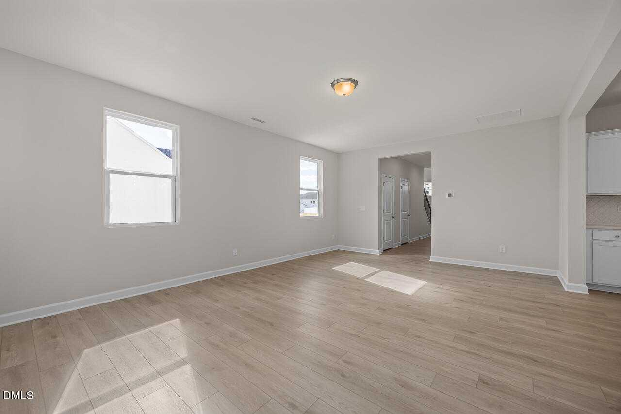 Bright master bedroom with light hardwood floors, white walls, large windows in Davidson Homes The Gavin C, Lillington, NC