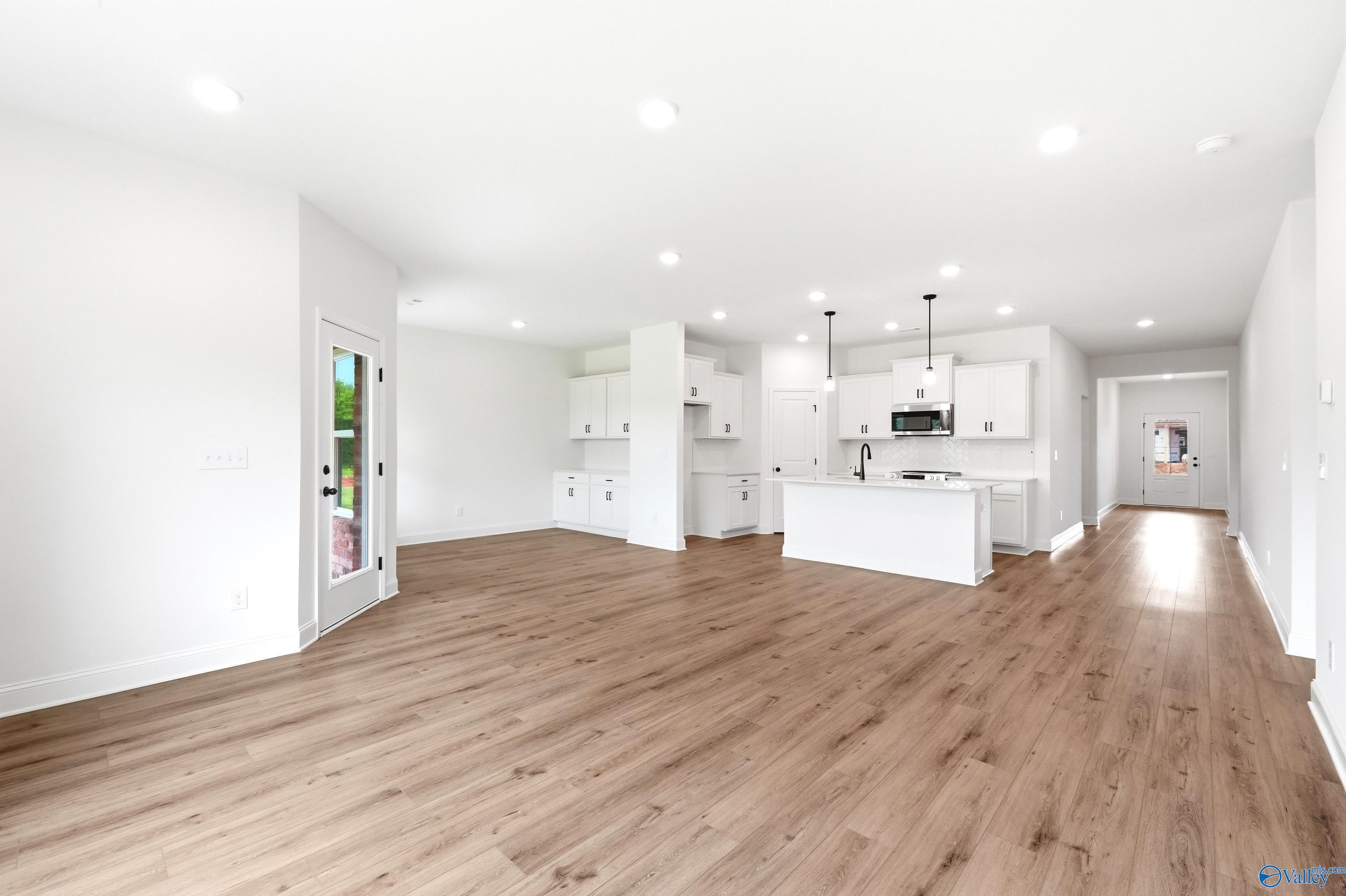Open-concept kitchen and living area with white cabinets in The Daphne C floor plan at Ivy Hills, Toney, Alabama.