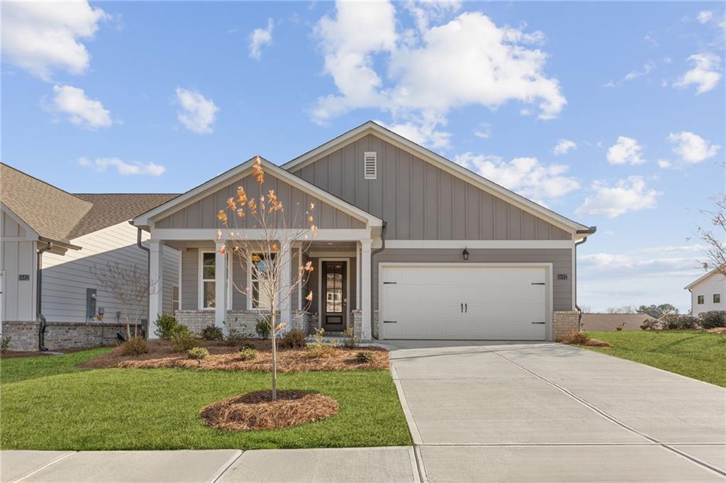 Modern gray 1-story home with covered front porch, 2-car garage, and landscaped yard in Kelly Preserve, Loganville, Georgia - Davidson Homes The Edison B