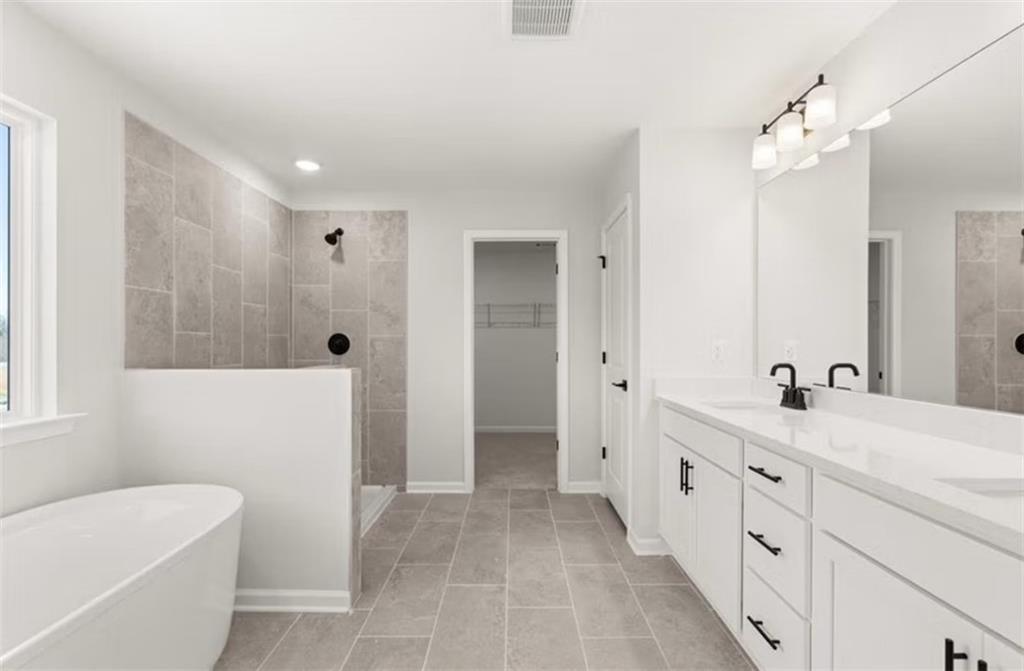 Luxurious master bathroom featuring freestanding tub, tiled walk-in shower, and double vanity in Davidson Homes The Hickory B, Winder, GA
