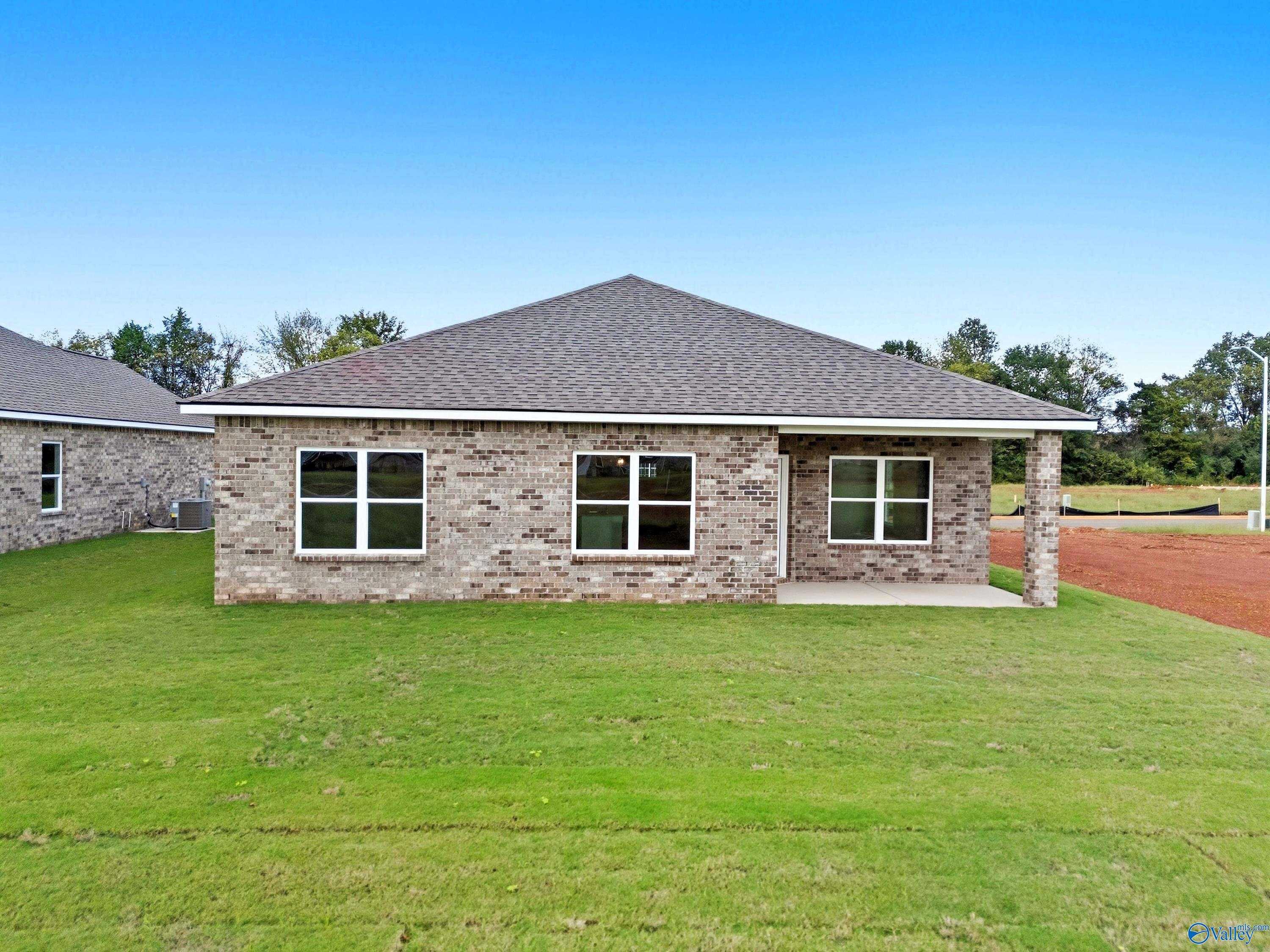Single-story brick home with gabled roof, covered porch, and lush green lawn in Lynn Meadows, Meridianville, Alabama - The Franklin by Davidson Homes