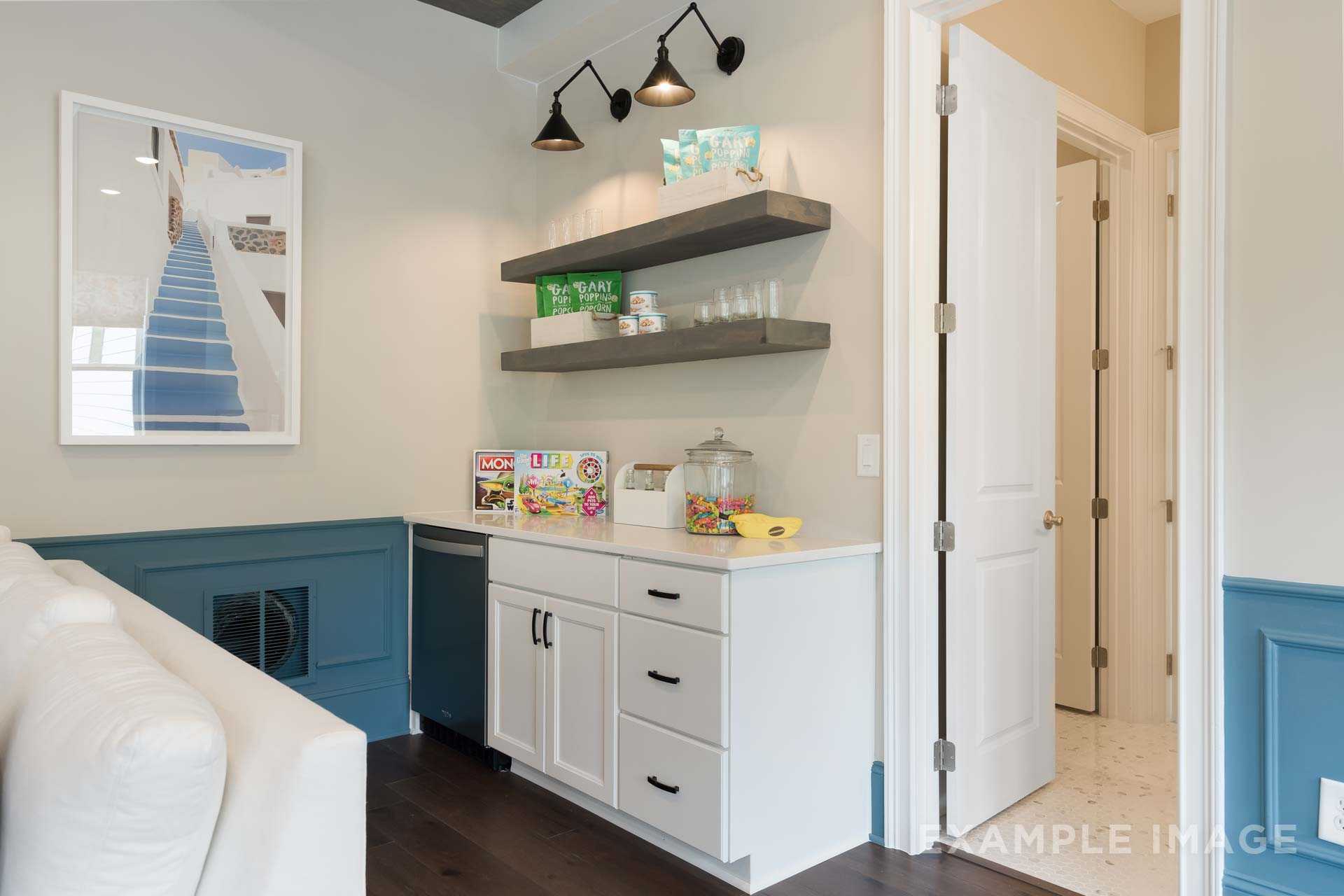 Butler's pantry in The Seaside home design with white cabinets, sink, stocked open shelves, and blue accent wall