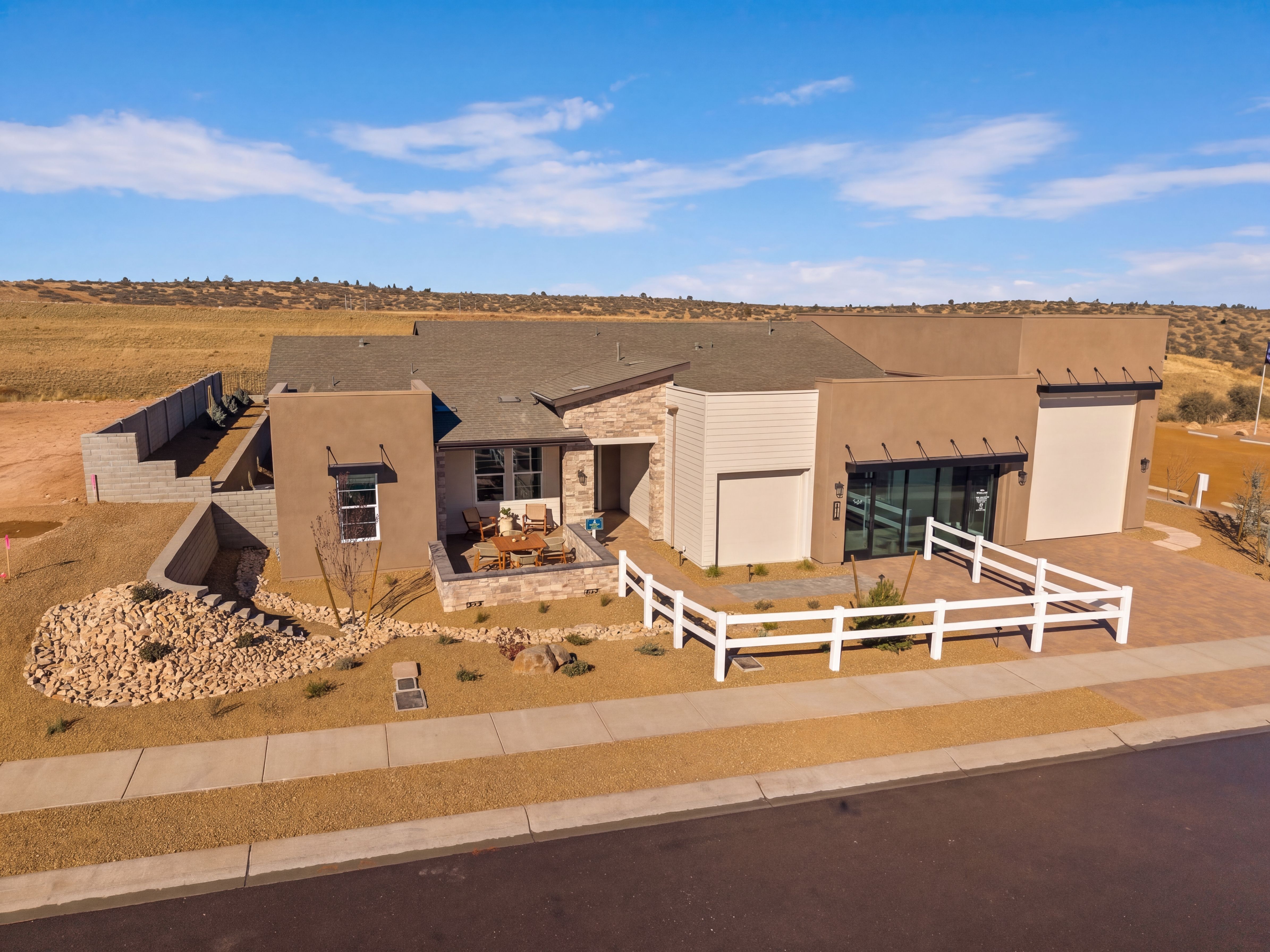 Contemporary Davidson Homes model home exterior at Hidden Hills in Prescott, AZ with a stone patio and white fence.