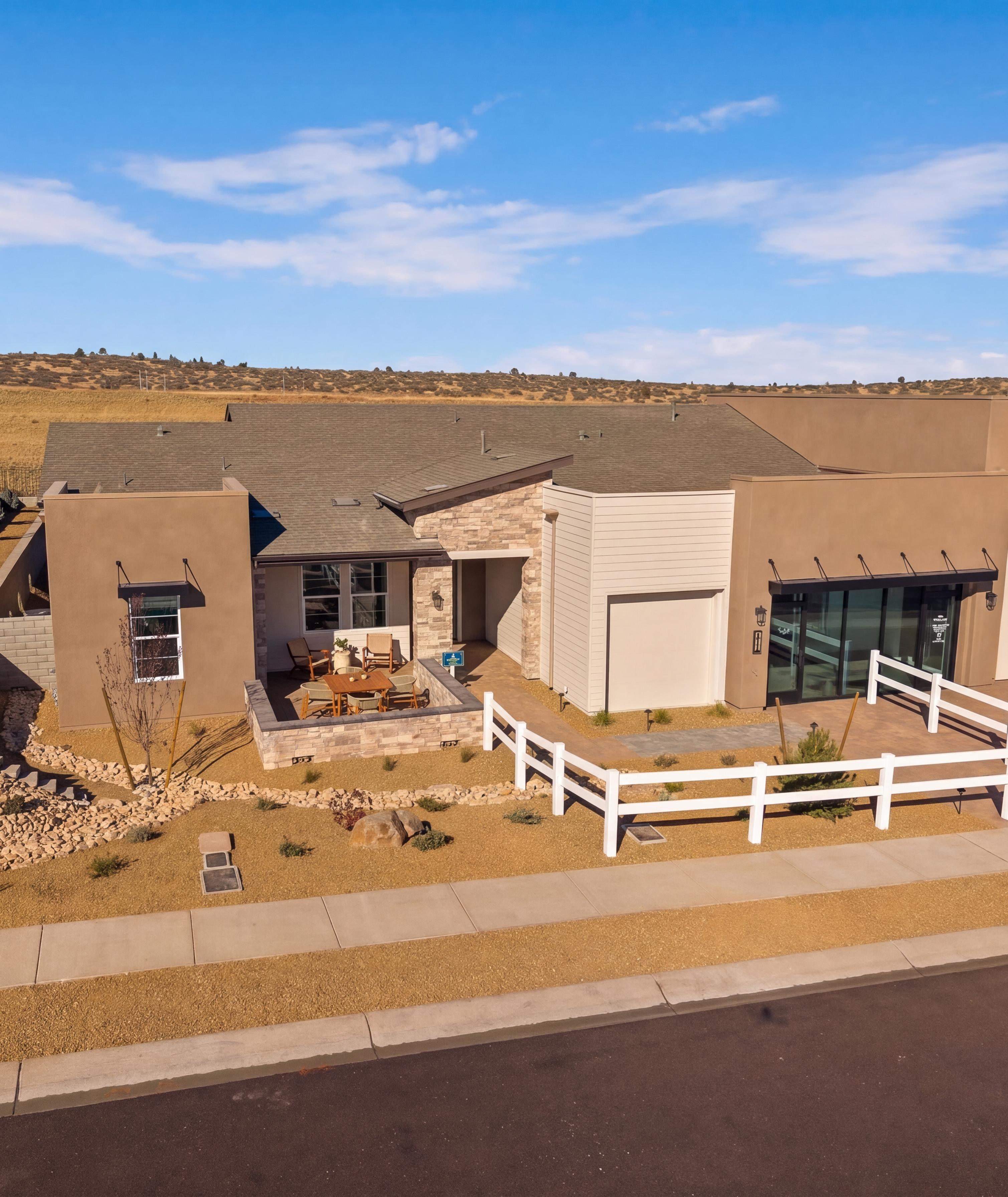 Contemporary Davidson Homes model home exterior at Hidden Hills in Prescott, AZ with a stone patio and white fence.