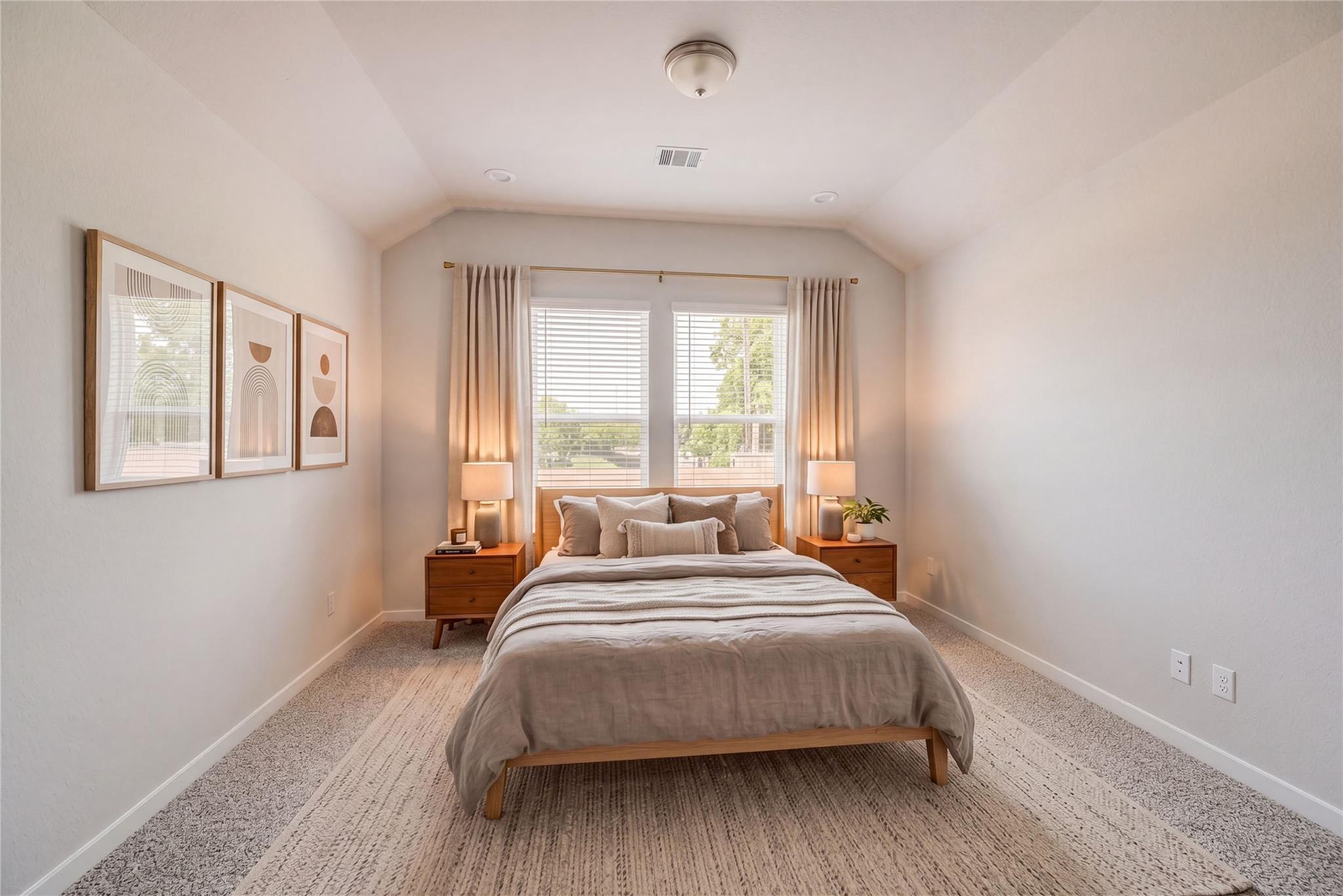 Serene bedroom with neutral walls, wooden platform bed, abstract art, and large windows in Davidson Homes The Acadia C, Magnolia, Texas