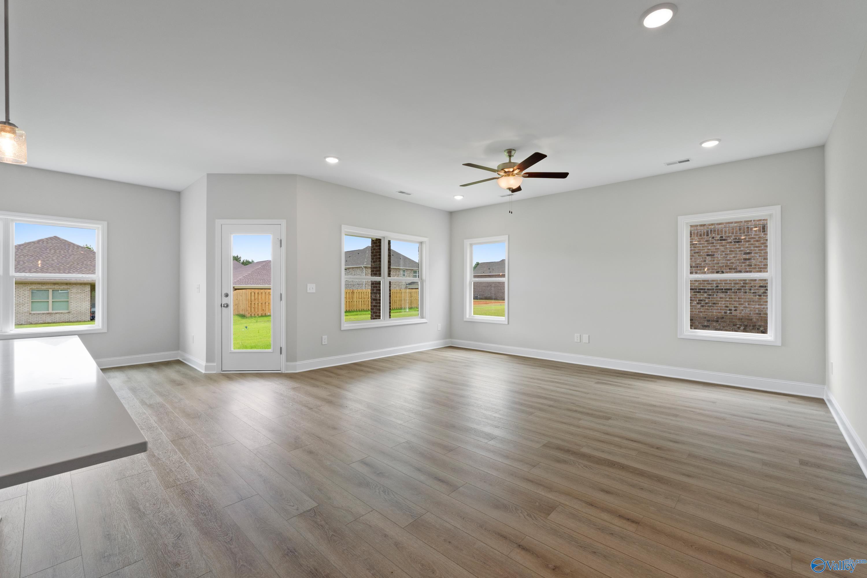Bright open living room with hardwood floors, large windows to backyard, ceiling fan in Davidson Homes The Franklin C, Harvest, Alabama