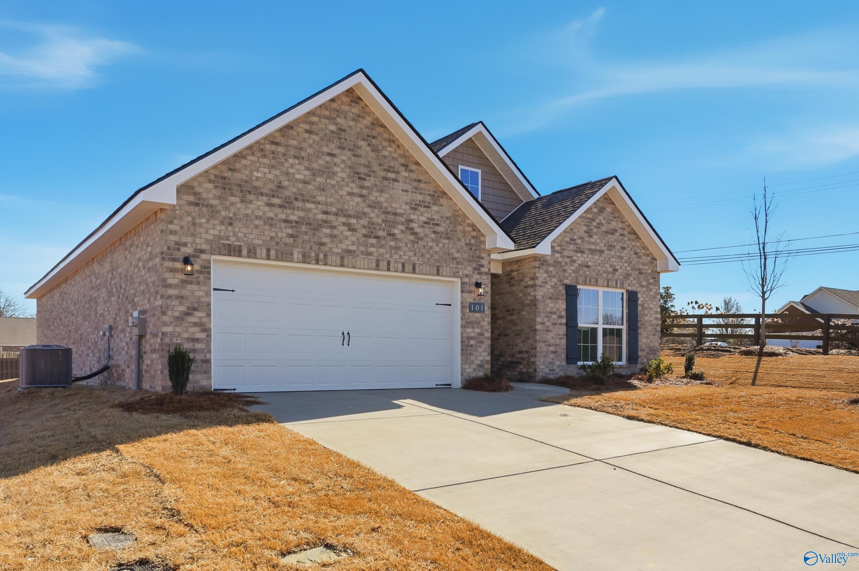 Modern brick ranch home with gabled roof, 2-car garage, and driveway in Flint Meadows, New Market, Alabama