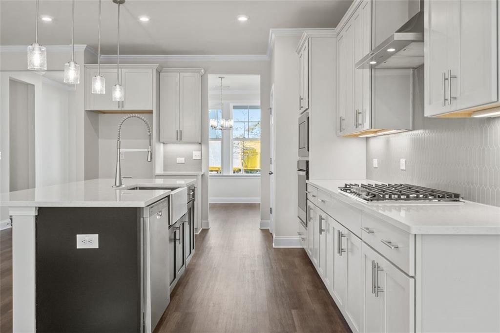 Modern kitchen with white shaker cabinets, black island sink, quartz counters, stainless appliances in Davidson Homes The Ash C, Hoschton, GA