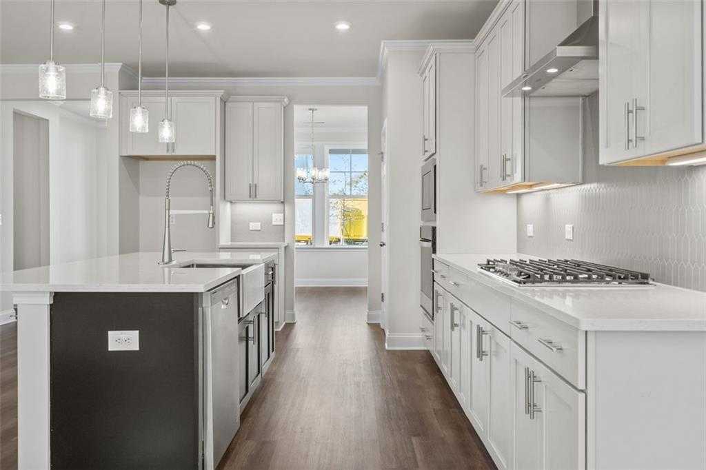 Modern kitchen with white shaker cabinets, black island sink, quartz counters, stainless appliances in Davidson Homes The Ash C, Hoschton, GA