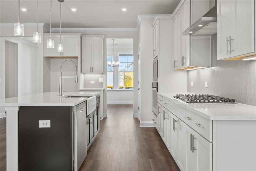 Modern kitchen with white shaker cabinets, black island sink, quartz counters, stainless appliances in Davidson Homes The Ash C, Hoschton, GA