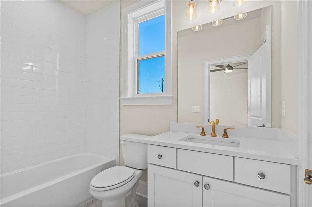 Elegant bathroom with white subway tiles, freestanding tub, gold faucet double vanity, and window in Davidson Homes The Arlington A, East Cobb, Georgia