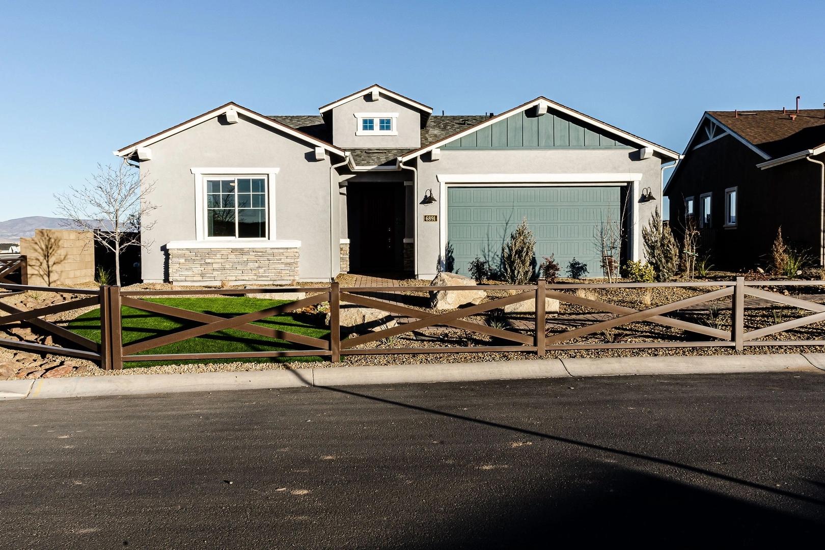 Contemporary gray home exterior at Westwood in Prescott AZ with wooden cross fence and desert mountain backdrop