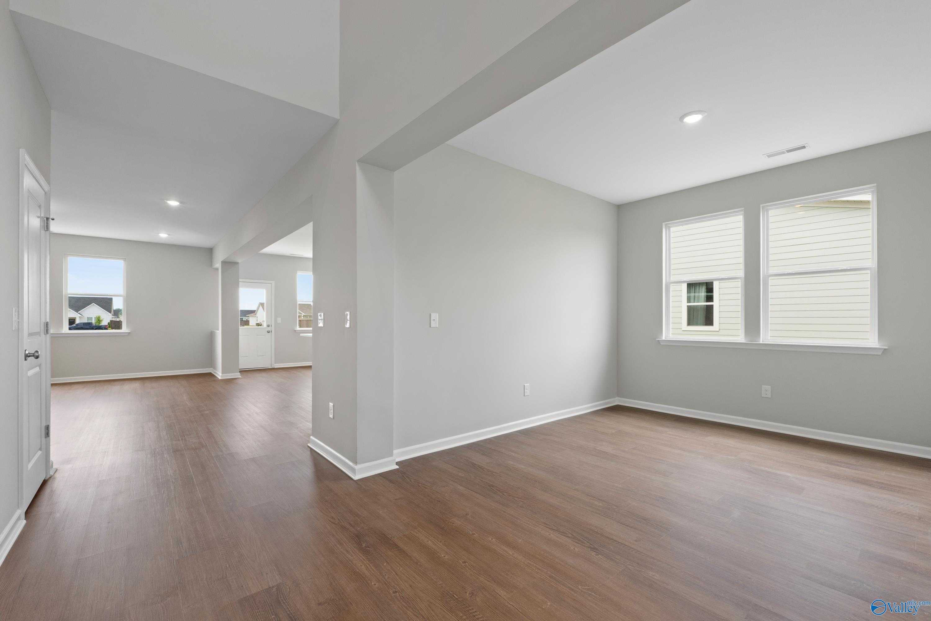 Spacious hallway with hardwood floors, large windows, and open layout in Davidson Homes The Dorado, Athens, Alabama