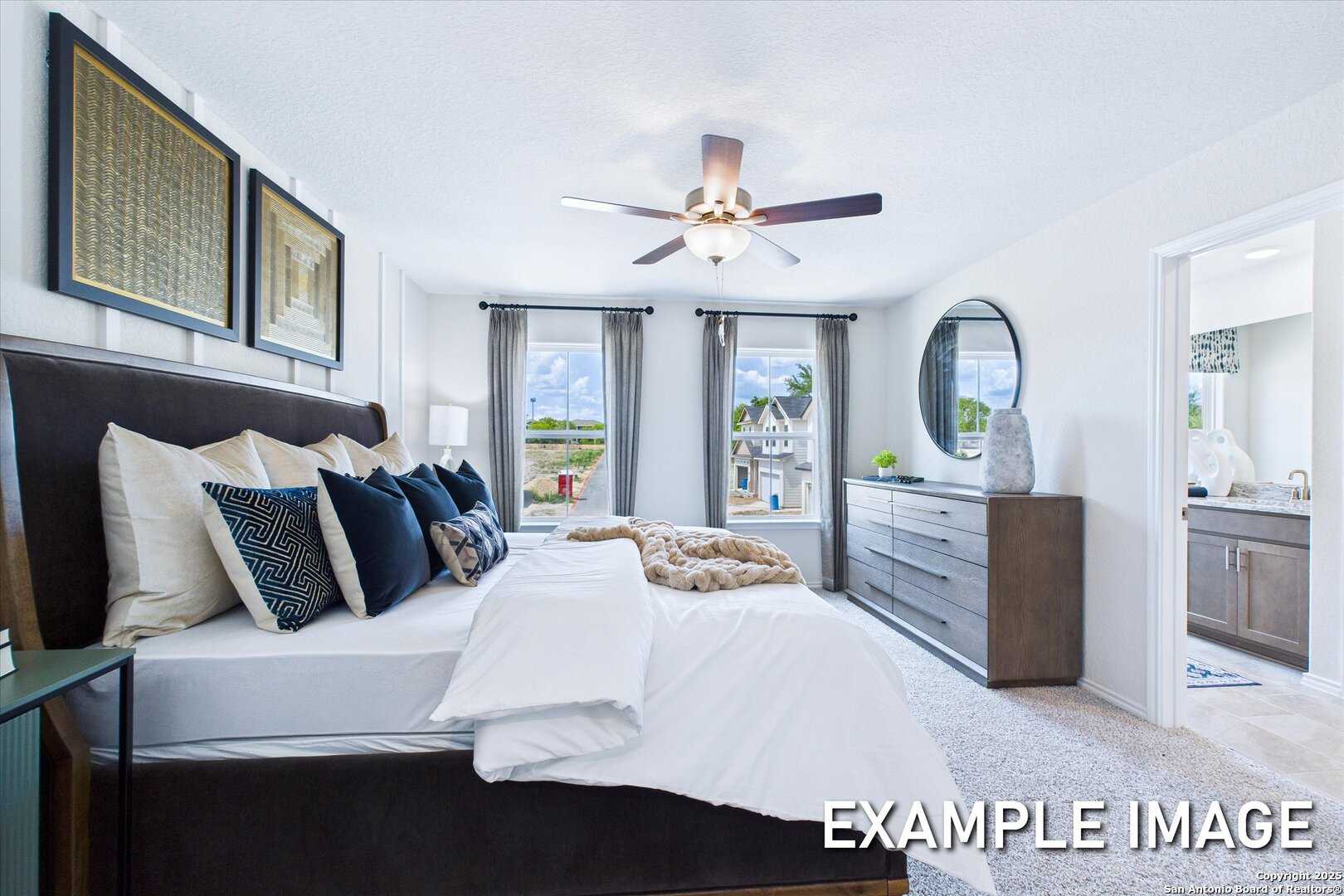 Luxurious master bedroom with plush king bed, ceiling fan, and en-suite bath in Davidson Homes The Gillian C, San Antonio