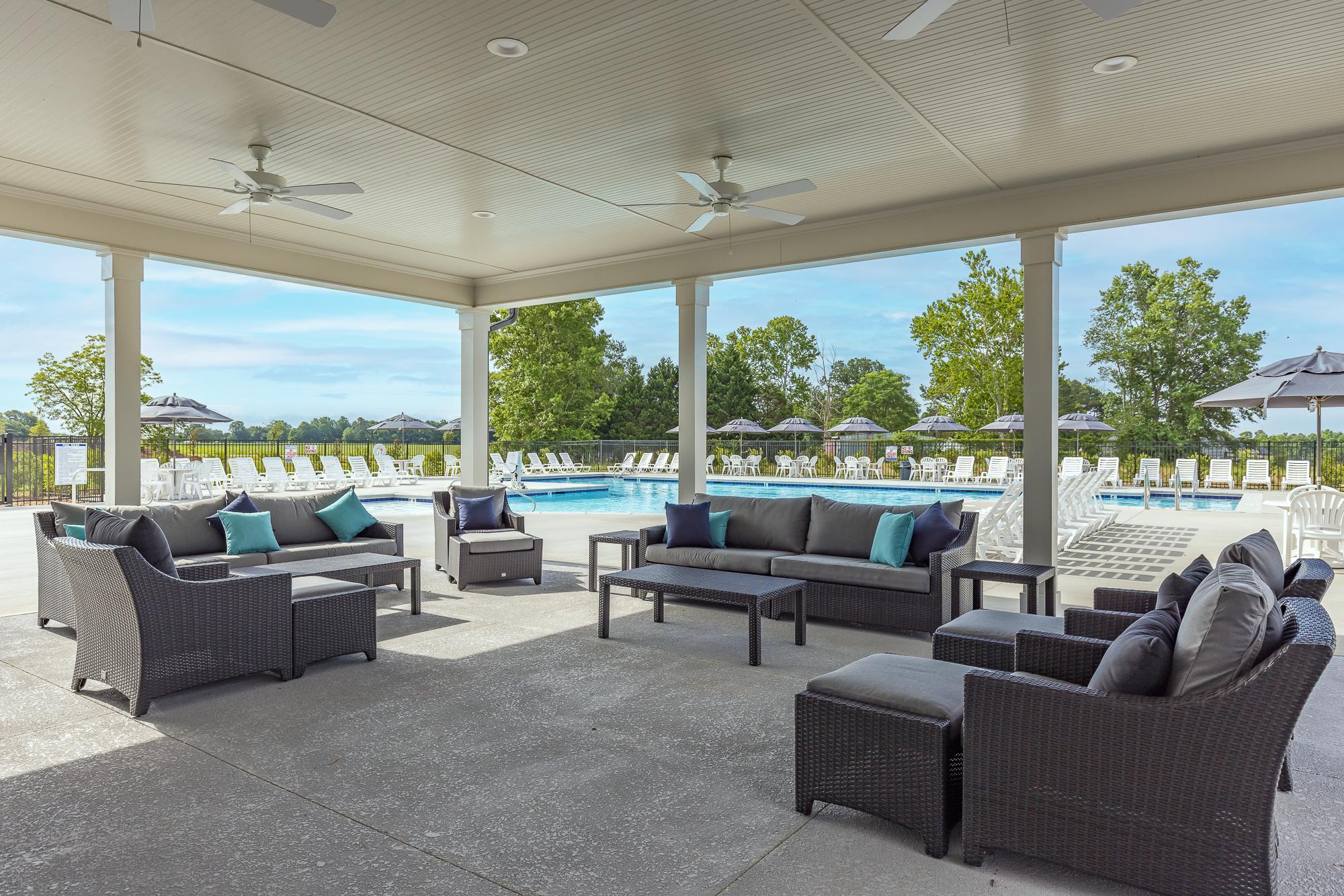 Covered poolside pavilion at Beverly Place in Four Oaks NC with wicker sectional seating and ceiling fans