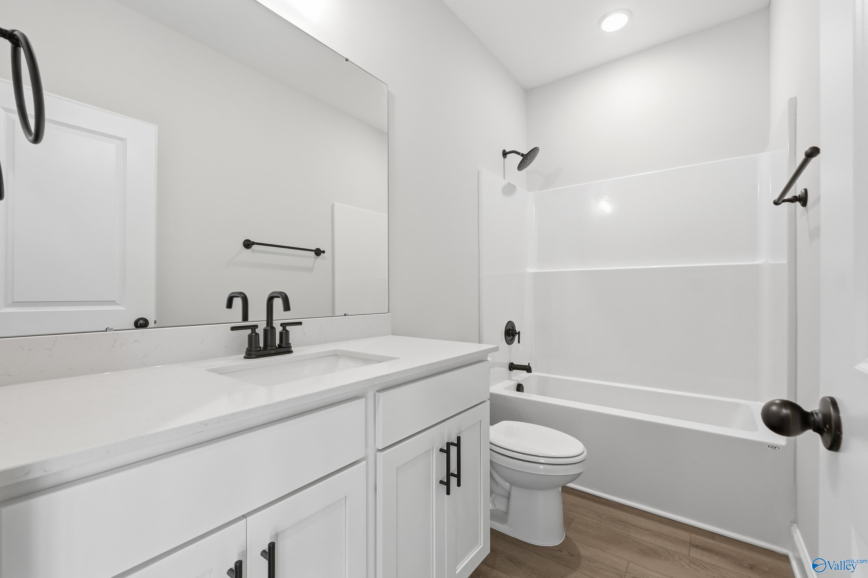 Modern white bathroom featuring bathtub, walk-in shower, and double-sink vanity in Davidson Homes The Daphne D, Arab, Alabama