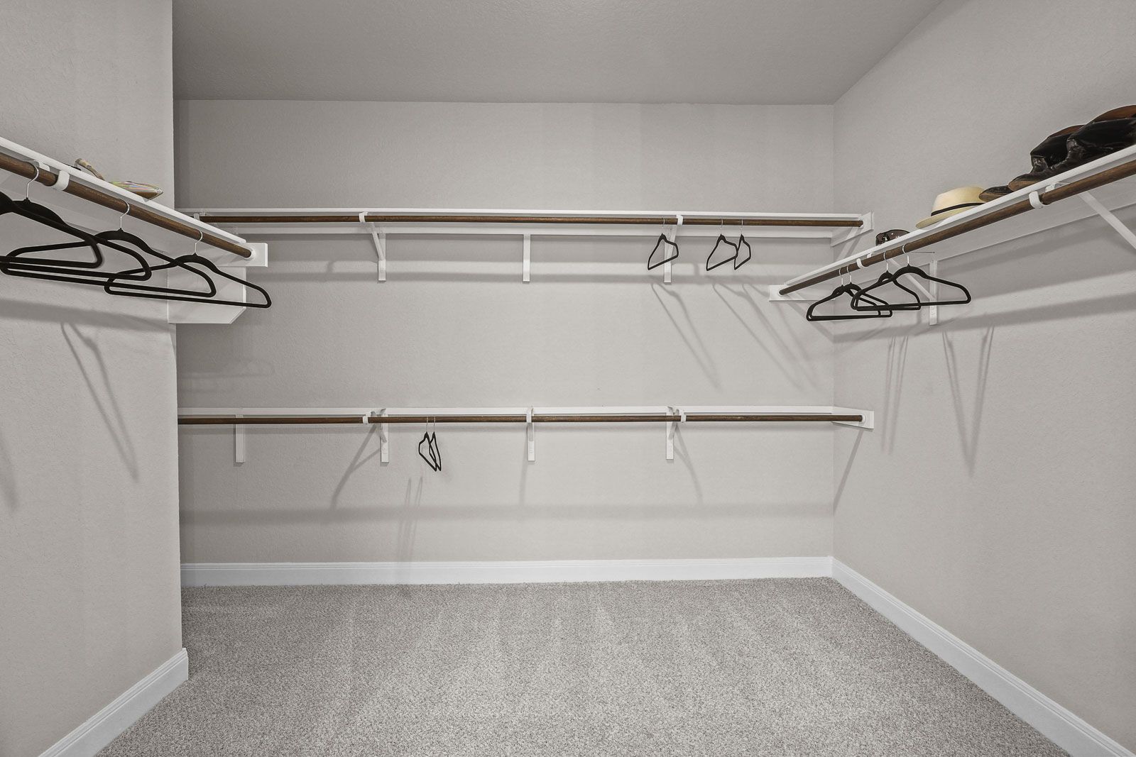 Spacious walk-in closet with tiered shelving and carpeted floors in The Jennings G master suite by Davidson Homes.