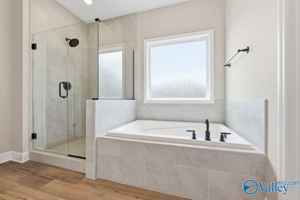 Modern master bathroom with soaking tub and frameless glass shower in The Rockford floor plan, Cain Park, Hartselle, AL.