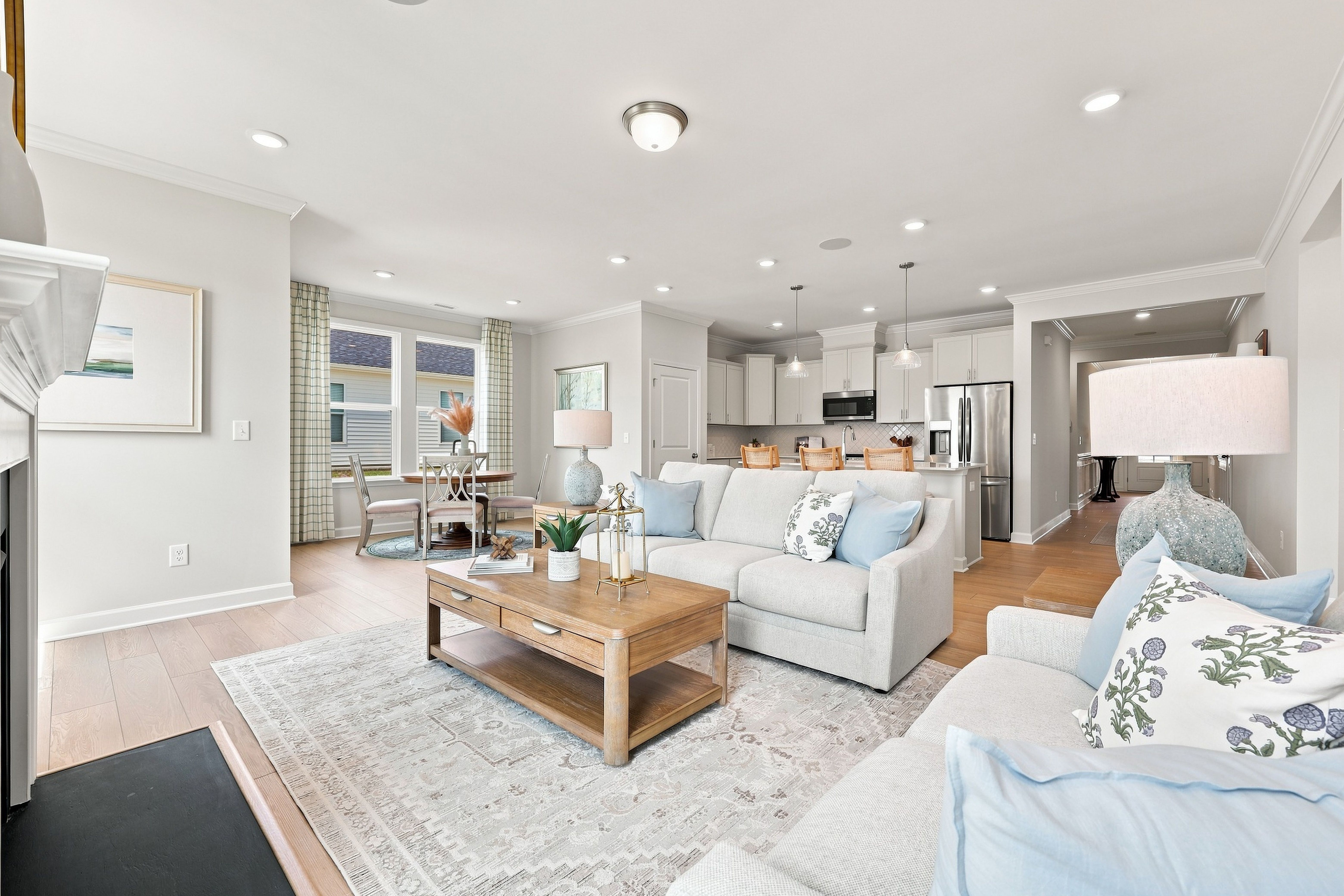 Open-concept living room and kitchen in The Daphne home design featuring a spacious floor plan and modern interior finishes.