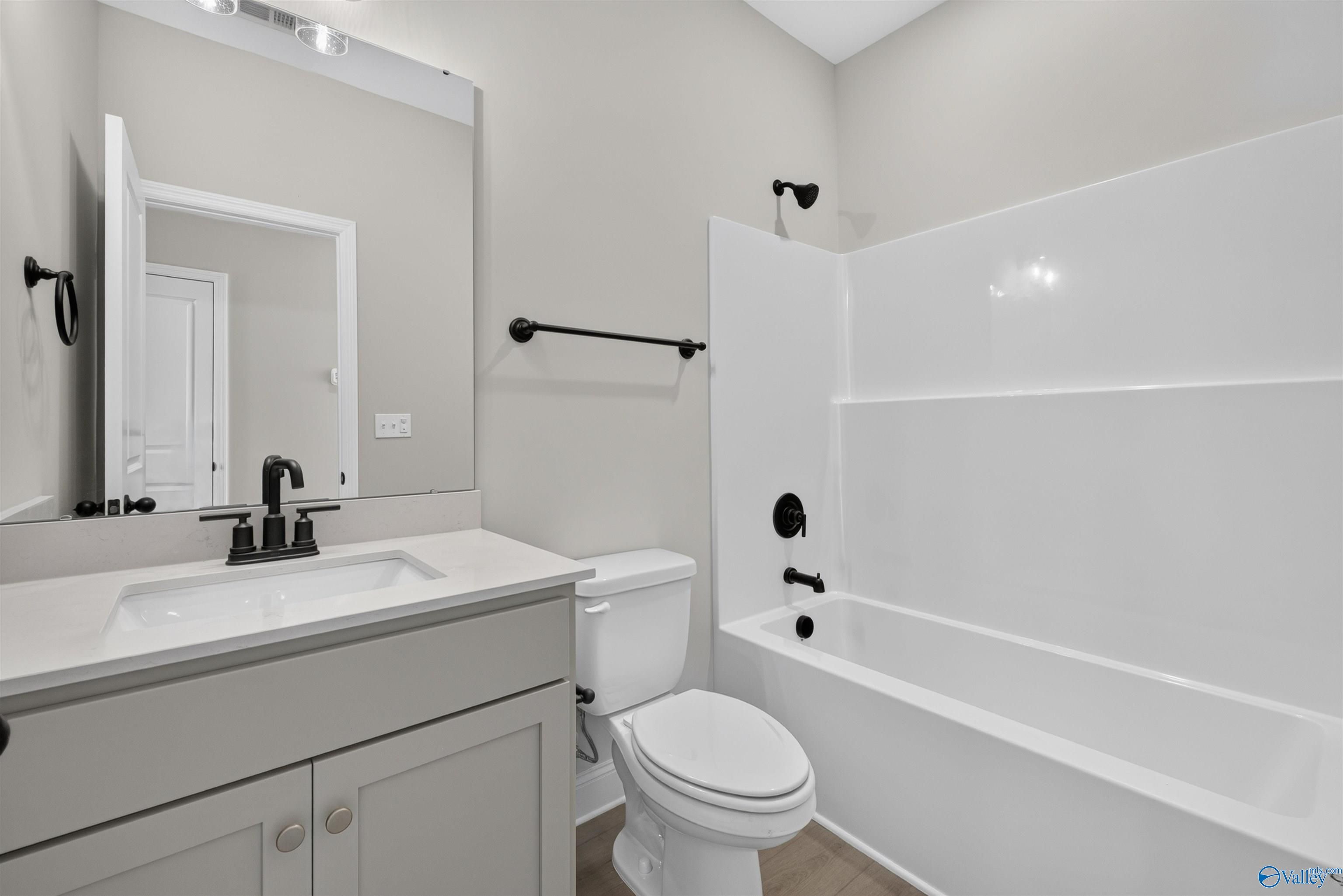 Modern bathroom with matte black fixtures, white vanity, and tub-shower combo in Davidson Homes The Butler plan, Hazel Green, AL