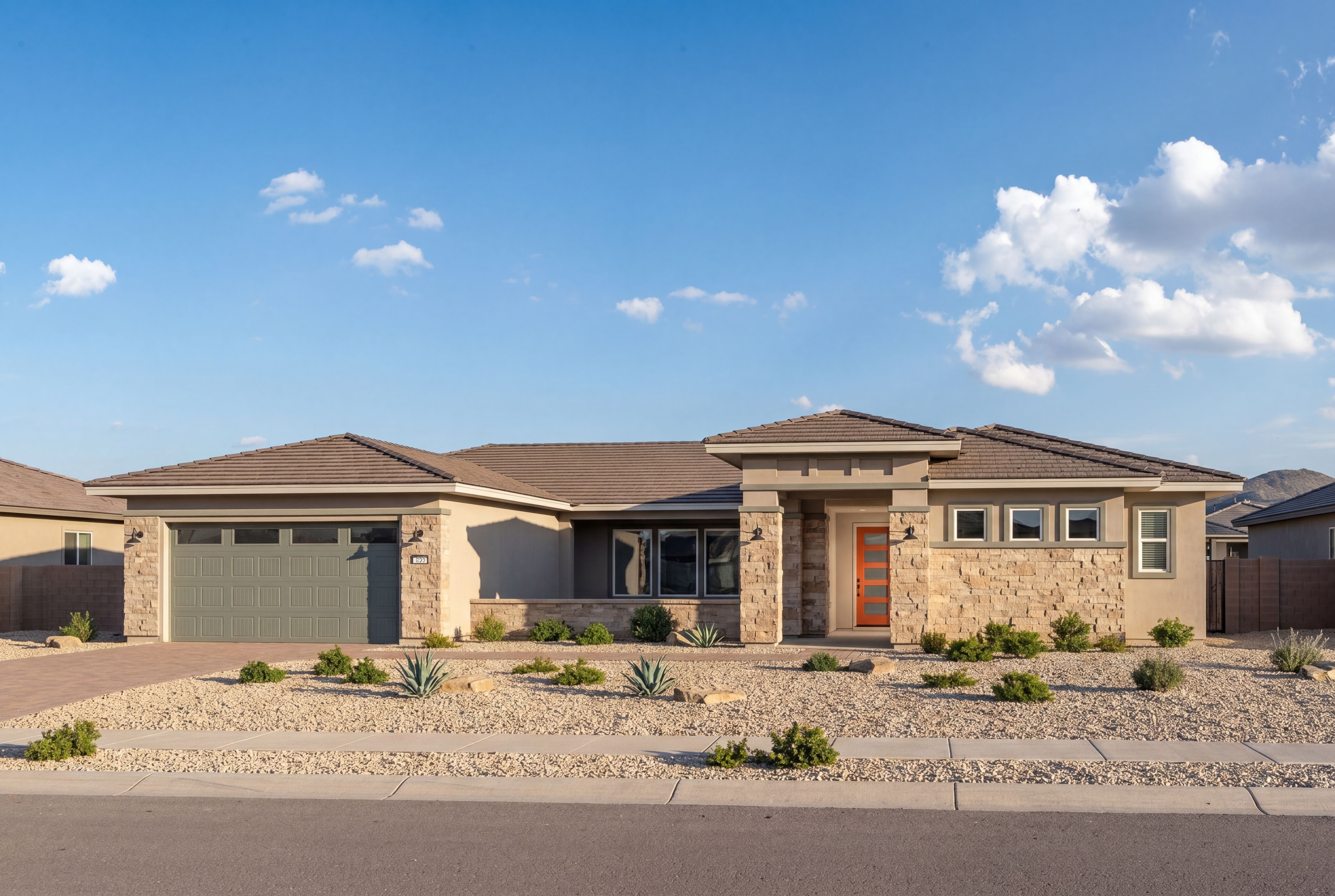 Contemporary single-story exterior of The Sundance in Prescott, featuring stone accents, desert landscaping, and garage.
