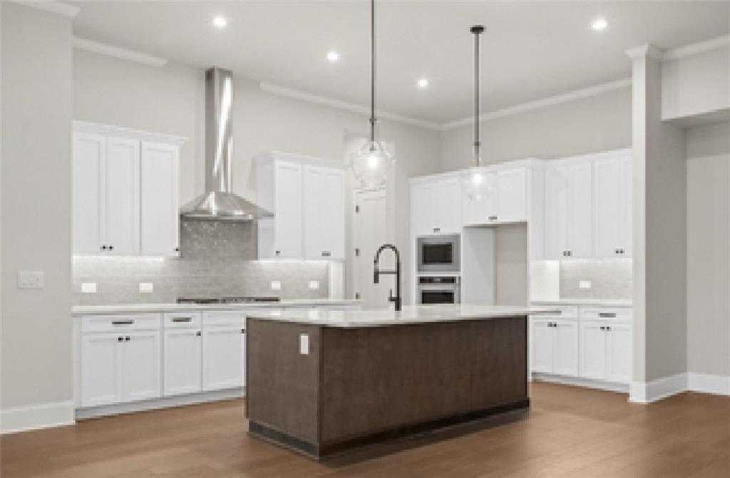 Modern kitchen with white shaker cabinets, quartz island, stainless appliances, subway backsplash in Davidson Homes Seaside A, Woodstock, GA