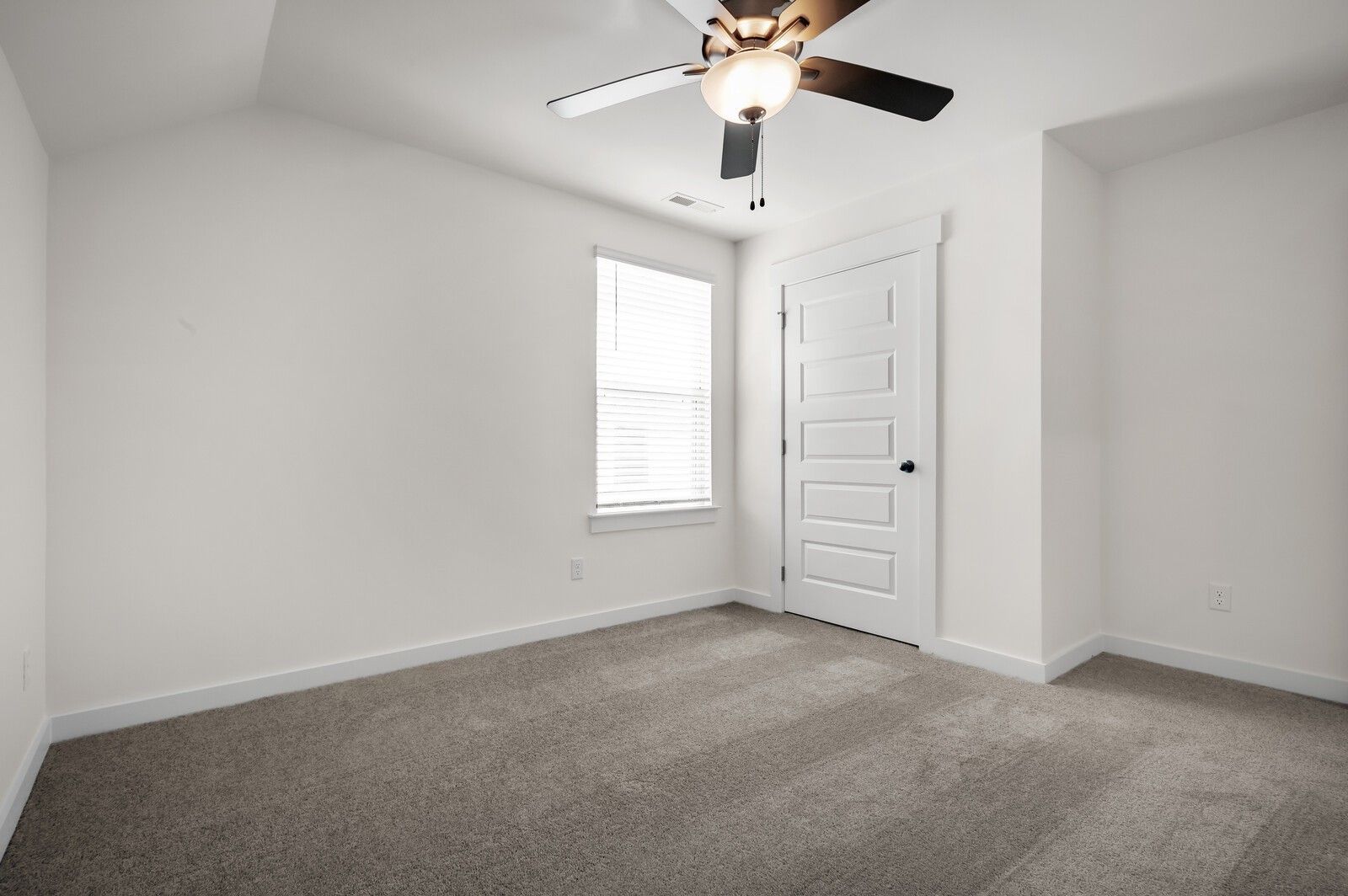 Bright, carpeted bedroom with ceiling fan in The Ash A floor plan at Woods Crossing, Gallatin, Tennessee.