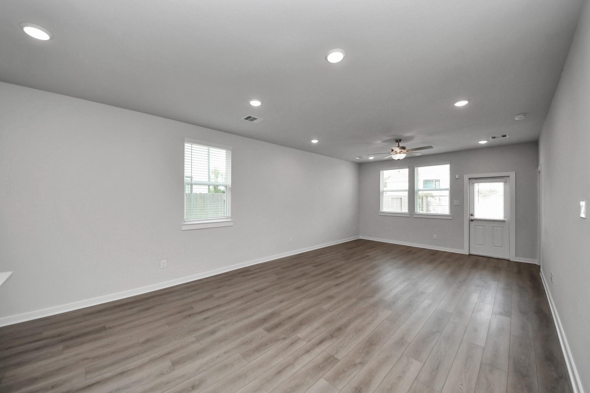Spacious open-concept living area with luxury vinyl plank flooring, recessed lighting, and ceiling fan in Davidson Homes' Frio F plan, Robins Landing Houston