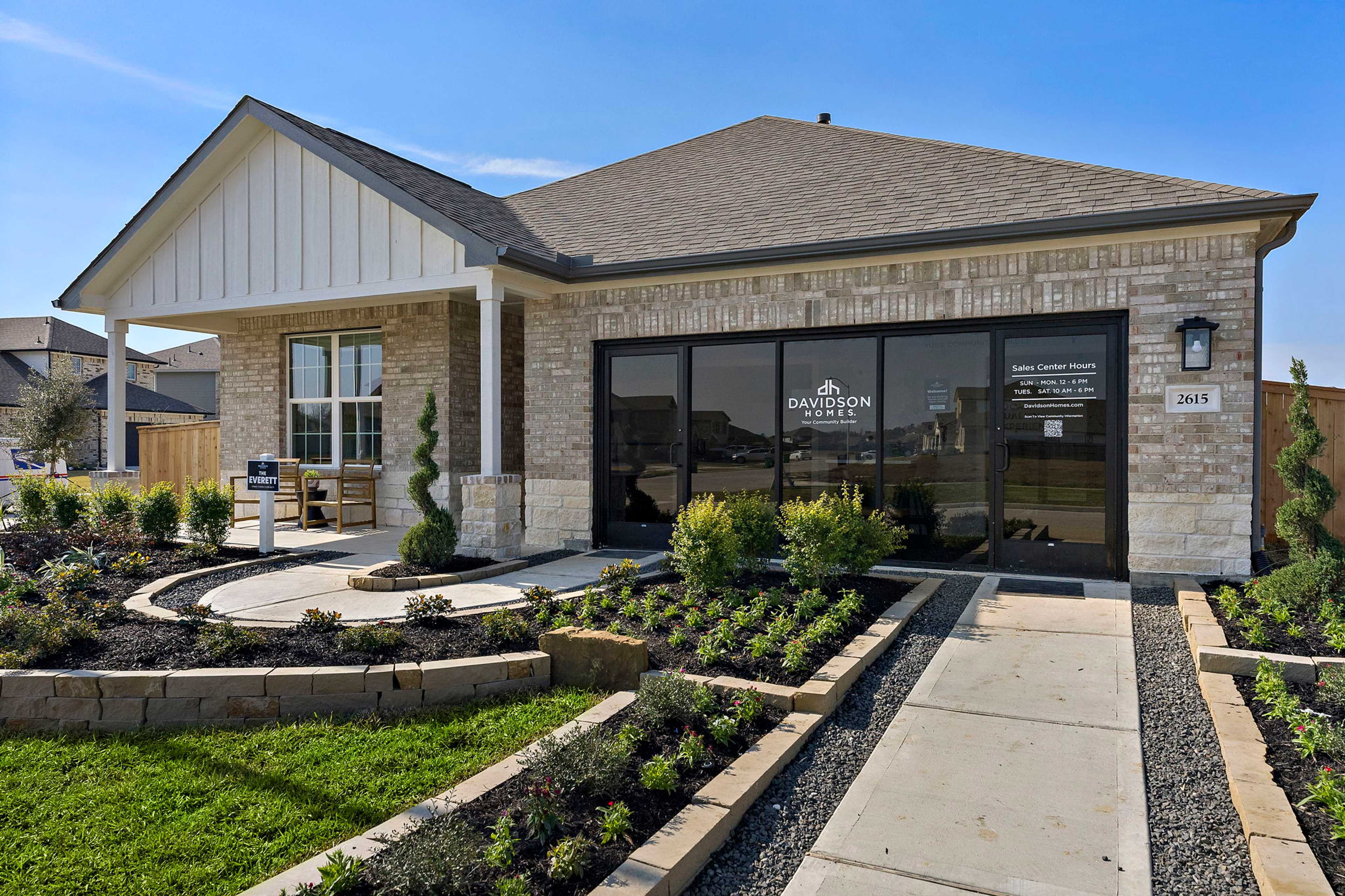Davidson Homes sales office at Sundance Cove in Crosby Texas with brick facade white trim and landscaped entry