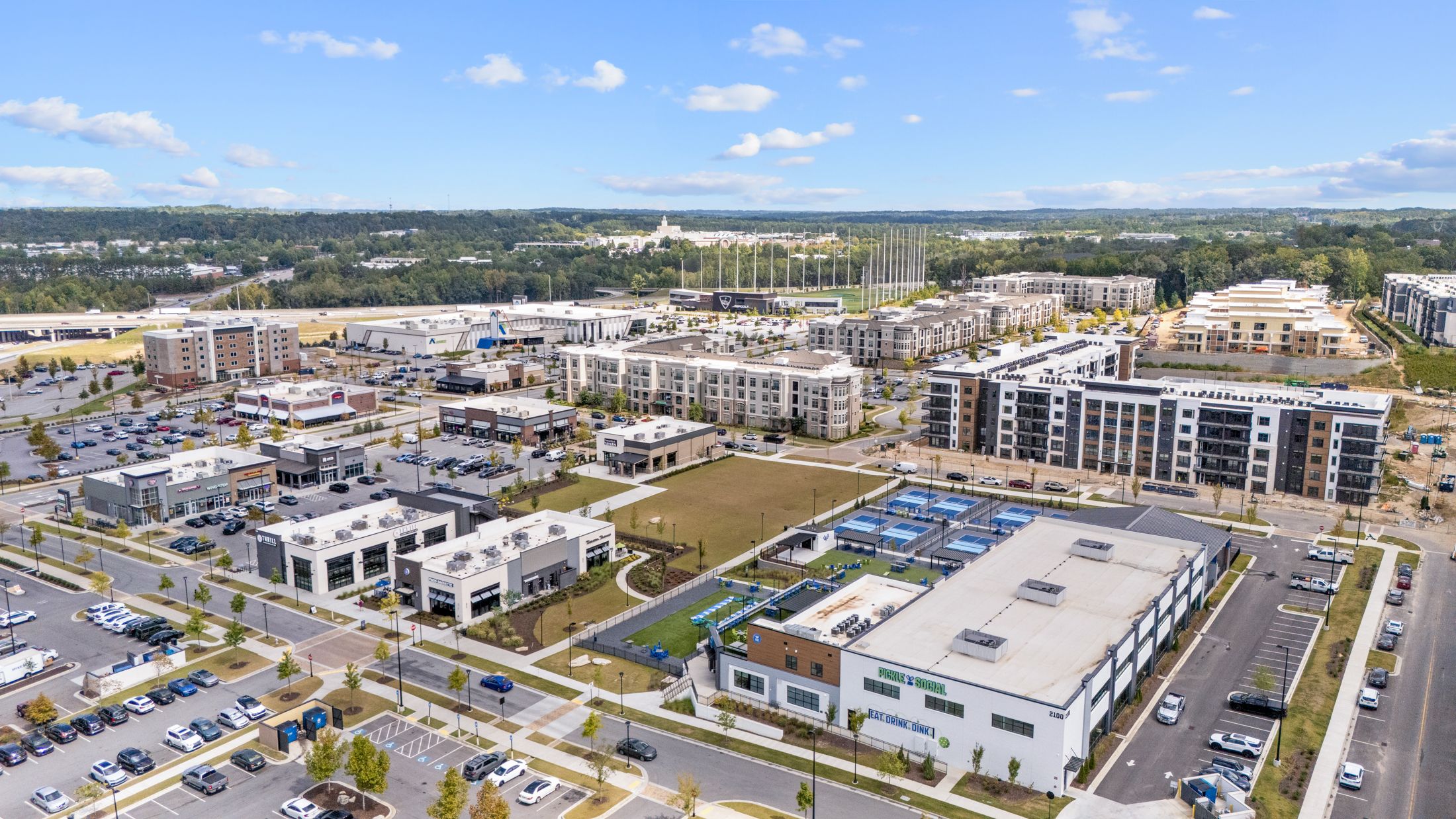 Aerial view of The Exchange at Buford near The Grove at East Thompson, featuring Pickle and Social and nearby apartments.