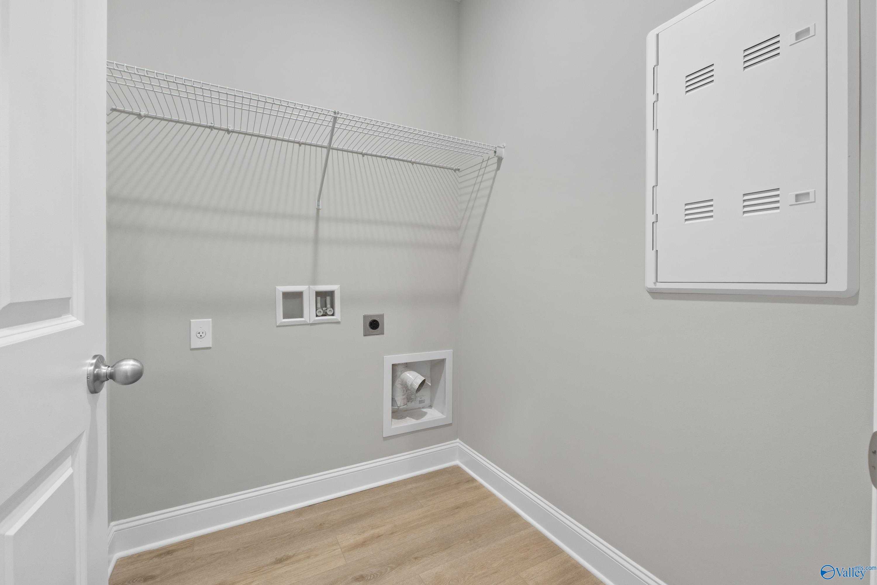 Functional laundry room with wire shelving, washer-dryer hookups in gray walls, The Asheville C by Davidson Homes, Athens AL