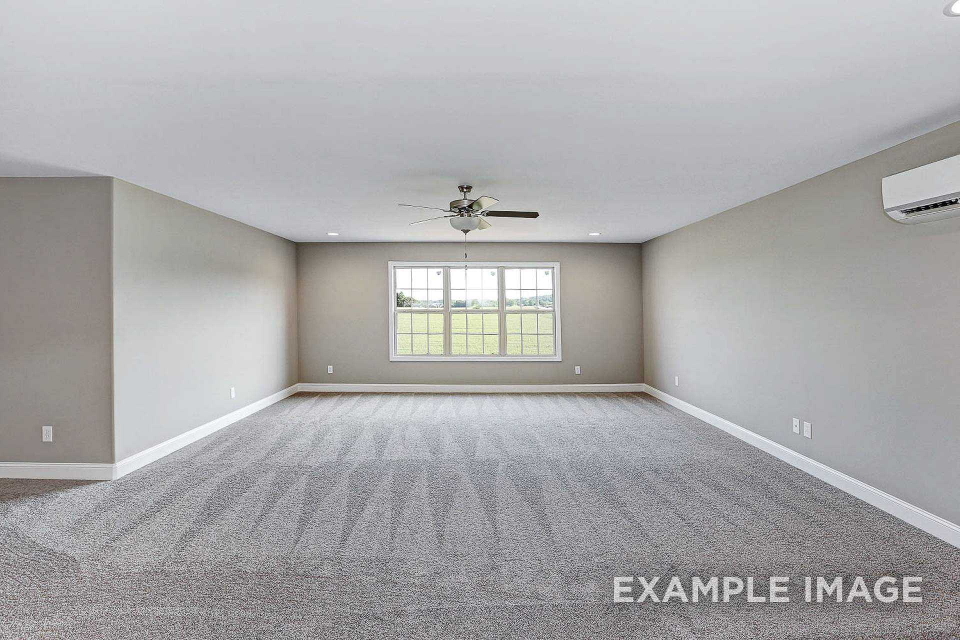 Spacious empty bonus room in The Montgomery B with gray walls, beige carpet, ceiling fan, and large windows overlooking green field