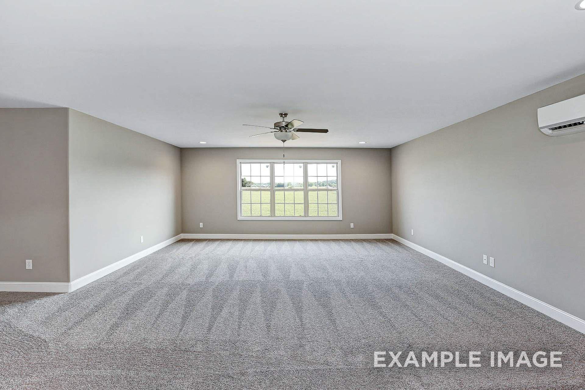 Spacious bonus room in The Montgomery C by Davidson Homes, with gray carpet, ceiling fan, and large window overlooking fields