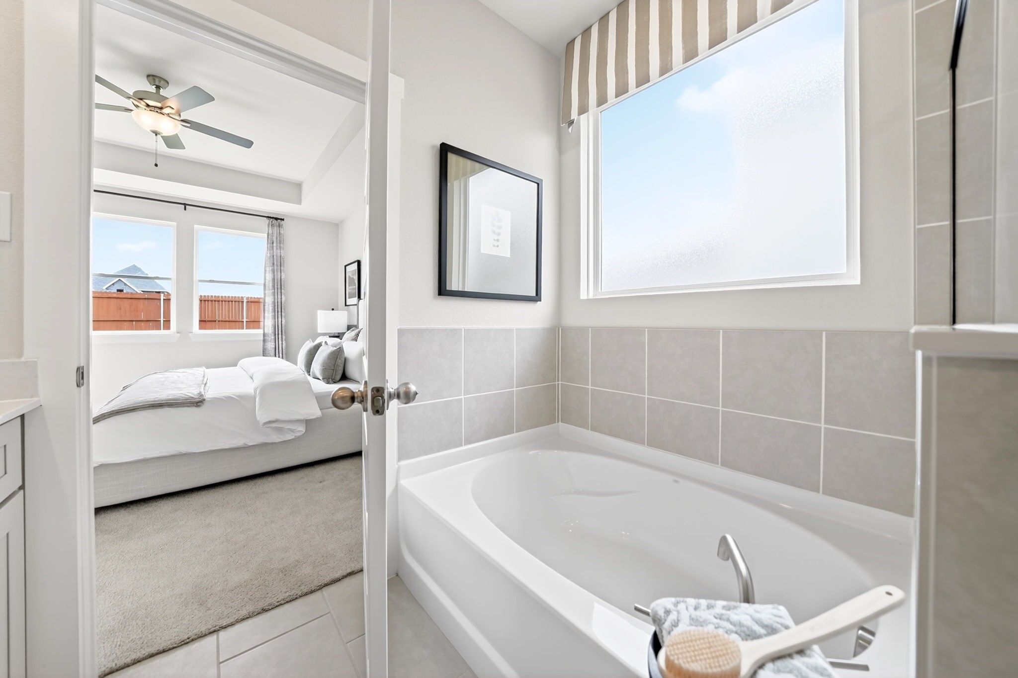 Primary bathroom with soaking tub and view into the master bedroom of The Laurel M floor plan in Anna, Texas.