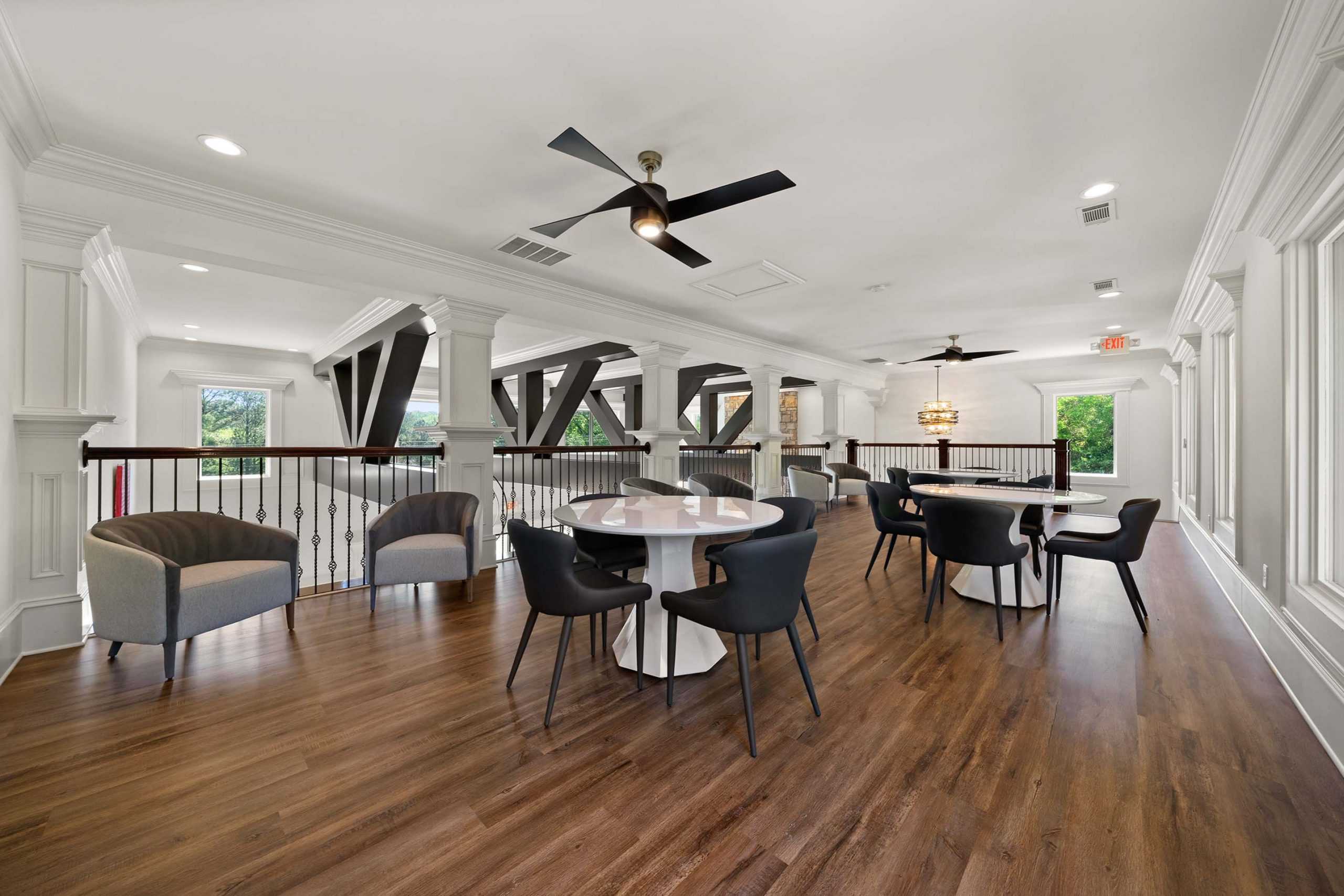 Spacious loft lounge at Mountainbrook in Cartersville GA with hardwood floors, exposed beams, round tables, and modern seating