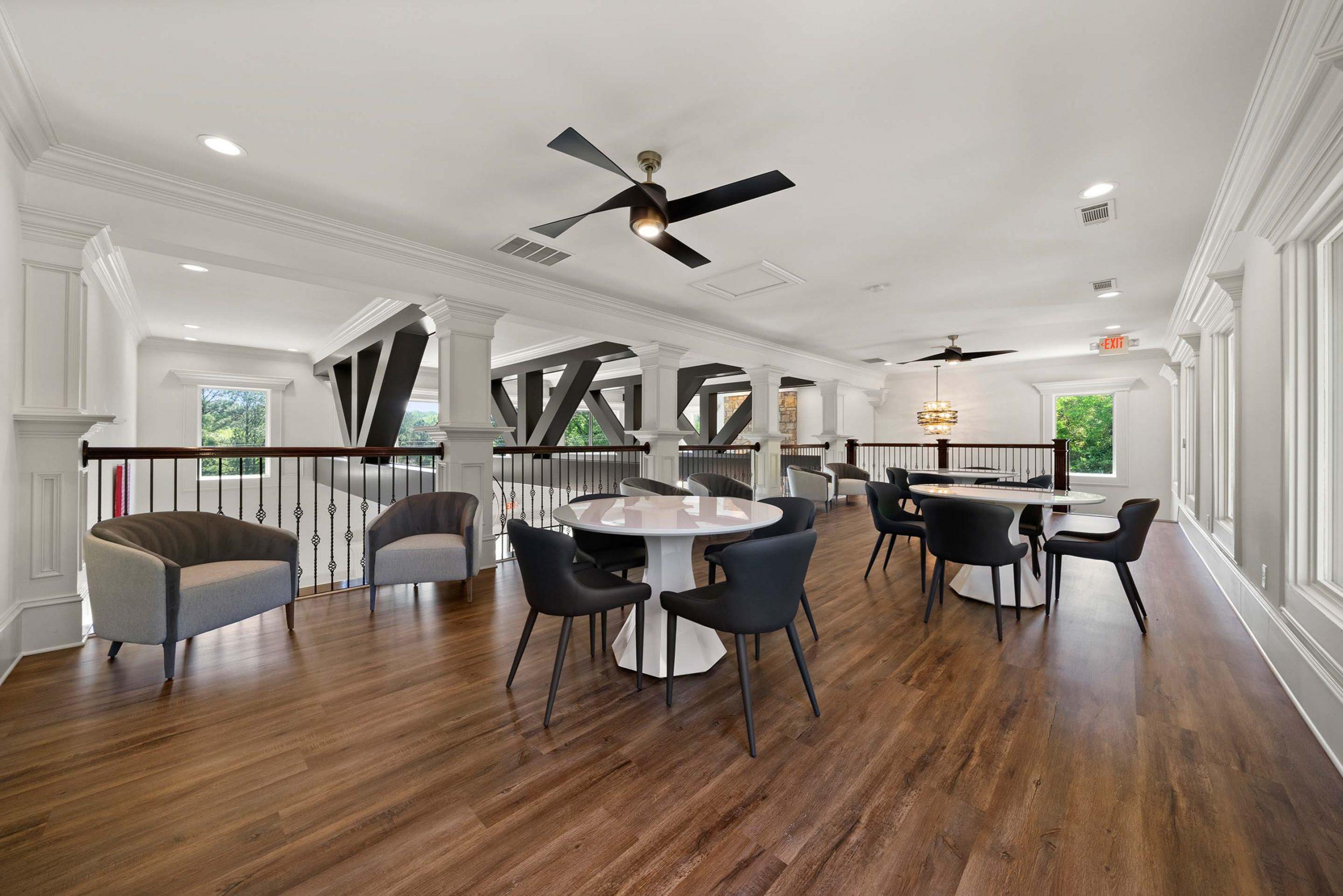 Spacious loft lounge at Mountainbrook in Cartersville GA with hardwood floors, exposed beams, round tables, and modern seating