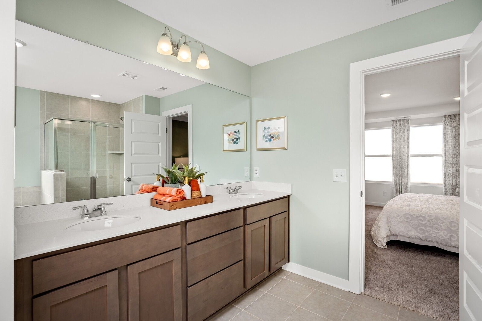 Elegant master bathroom featuring double vanity, glass shower, and bedroom view in Davidson Homes The Gordon C, White House, TN