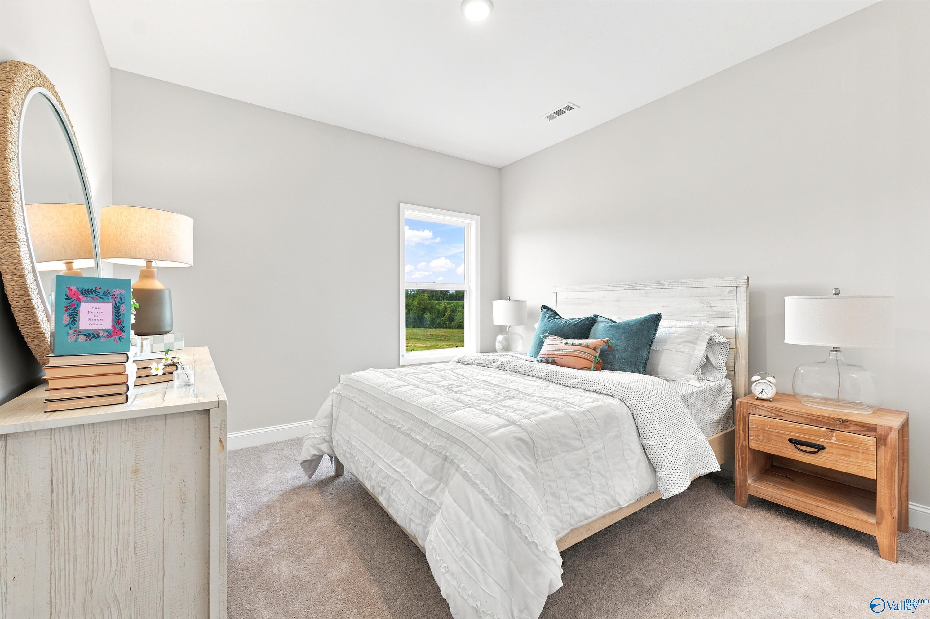 Bright, cozy bedroom with white furniture and decor in The Finleigh floor plan at Riverton Preserve, Huntsville, Alabama.