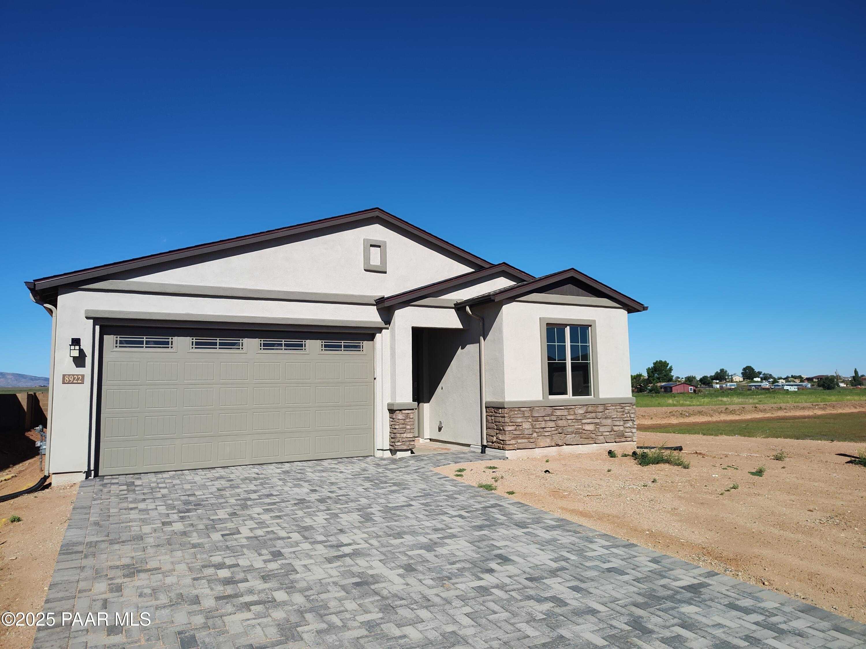 Modern single-story home with 3-car garage, stone accents and paver driveway in North Ridge at Pronghorn Ranch, Prescott Valley AZ