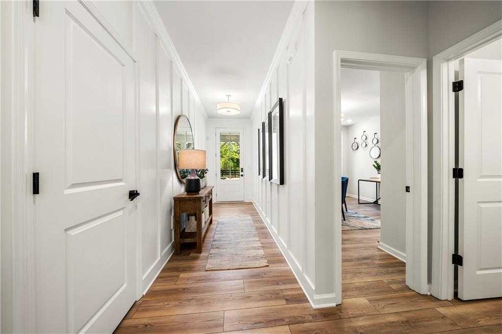 Elegant shiplap hallway with hardwood floors, console table, and mirrored decor in Davidson Homes The Hickory B, Riverwood, Dallas, Georgia