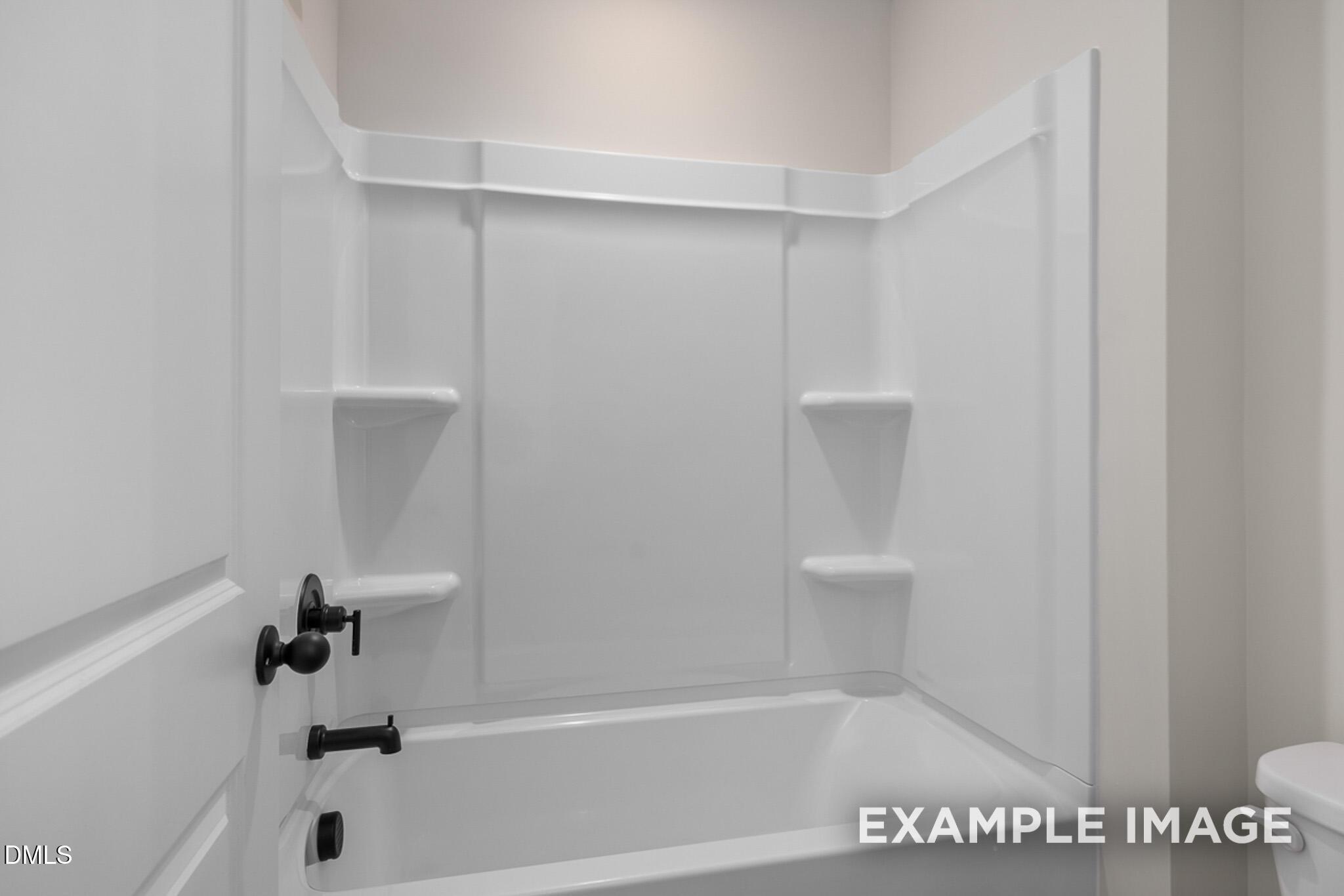 White bathtub and shower combo with sleek matte black fixtures in a Davidson Homes Mitchell floor plan, Knightdale, NC.