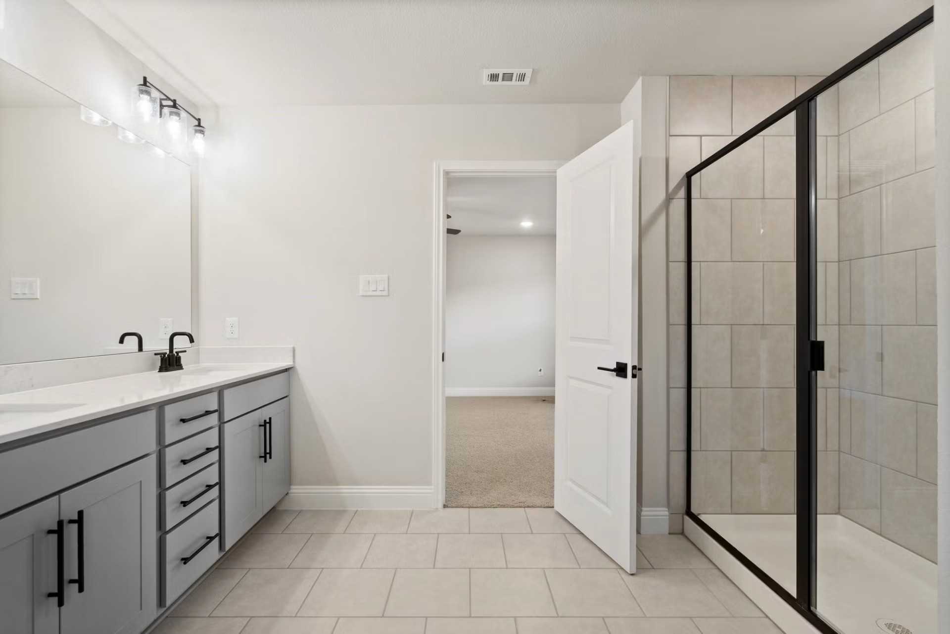 Modern master bathroom with double vanity, gray shaker cabinets, and glass shower in Davidson Homes The Wake D, Wylie, Texas
