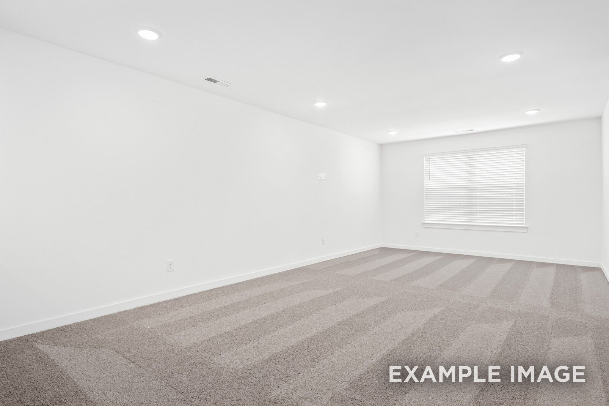 Empty bedroom featuring gray patterned carpet, white walls, recessed lighting, and large window blinds in Davidson Homes Ridgeport C, Gallatin, TN