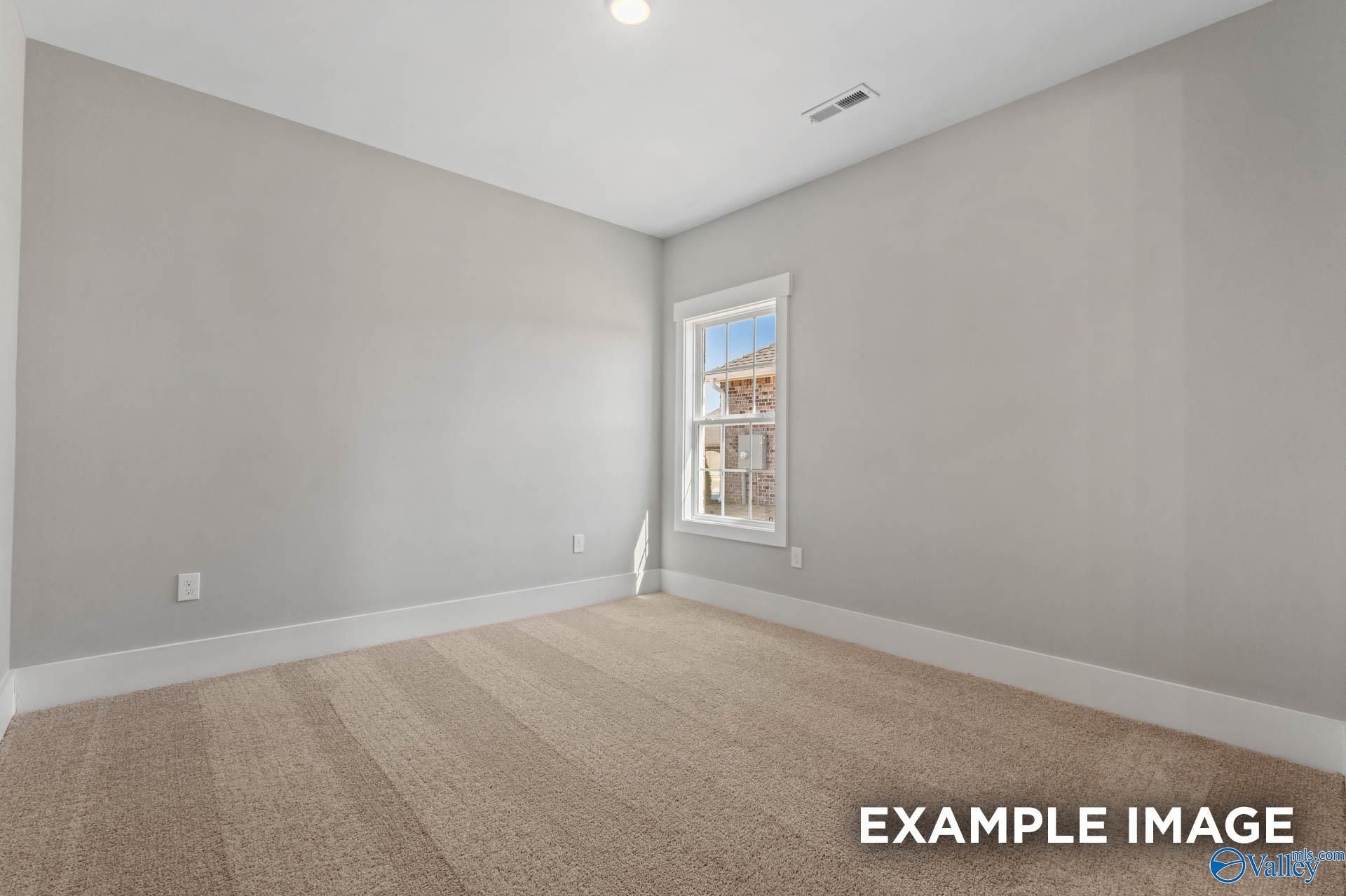 Bright, carpeted bedroom with neutral walls in The Finleigh floor plan by Davidson Homes in Briercreek, Meridianville.