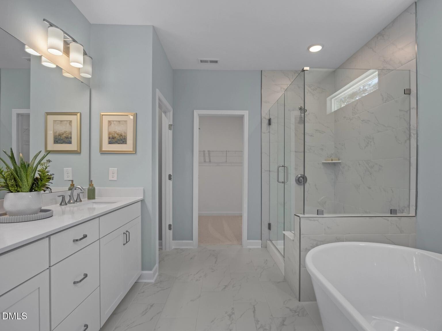 Elegant master bathroom with freestanding tub, glass shower, white vanity in Davidson Homes The Hickory II D, Wake Forest, NC