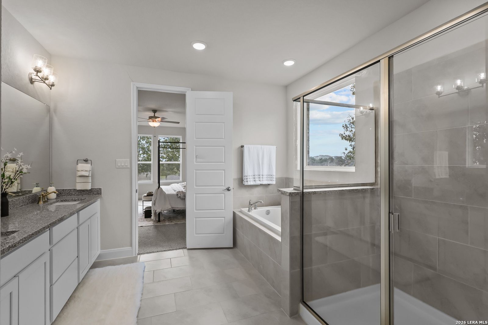 Primary bathroom with soaking tub, glass shower, and double vanity in The Lanier H floor plan, Ladera, San Antonio, TX.