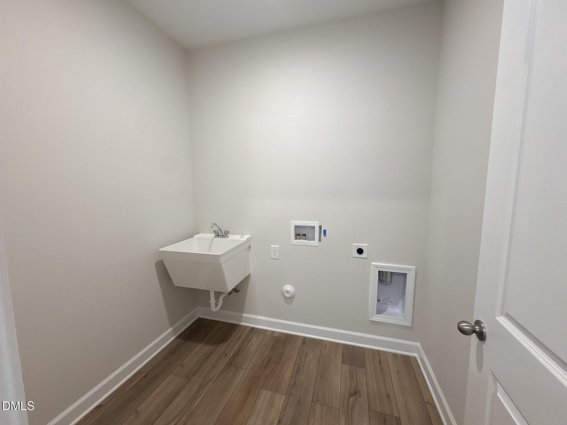 Laundry room with utility sink and washer hookups in The Ash C floor plan at Woodland Crossing, Zebulon, North Carolina.
