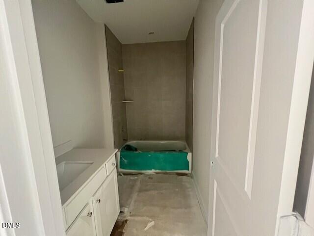 Unfinished bathroom featuring bathtub, white vanity, and tiled shower wall in 4-bedroom Davidson Homes The Preston A, Lillington, NC